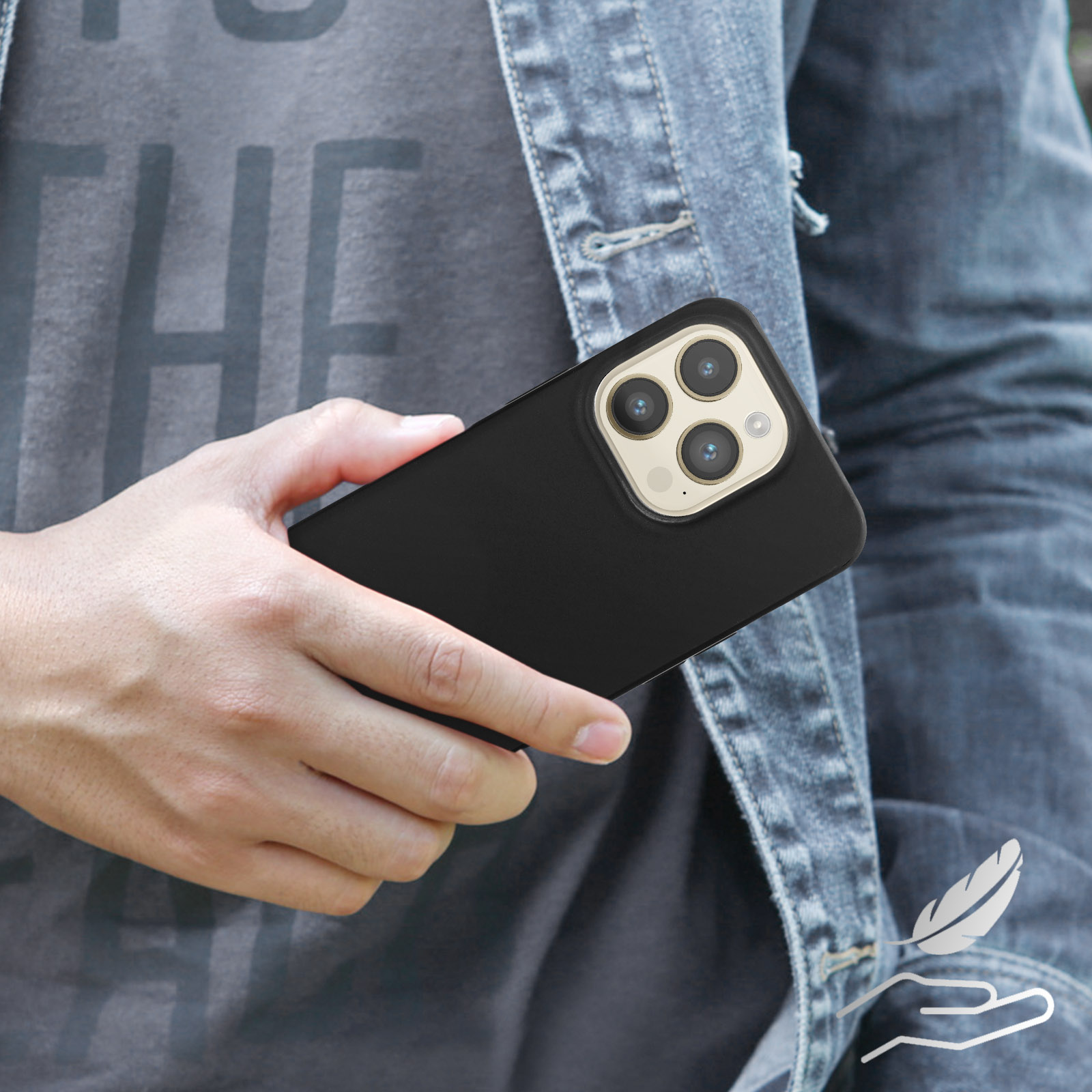 Una mano che tiene un telefono nero con tre fotocamere e un anello dorato.