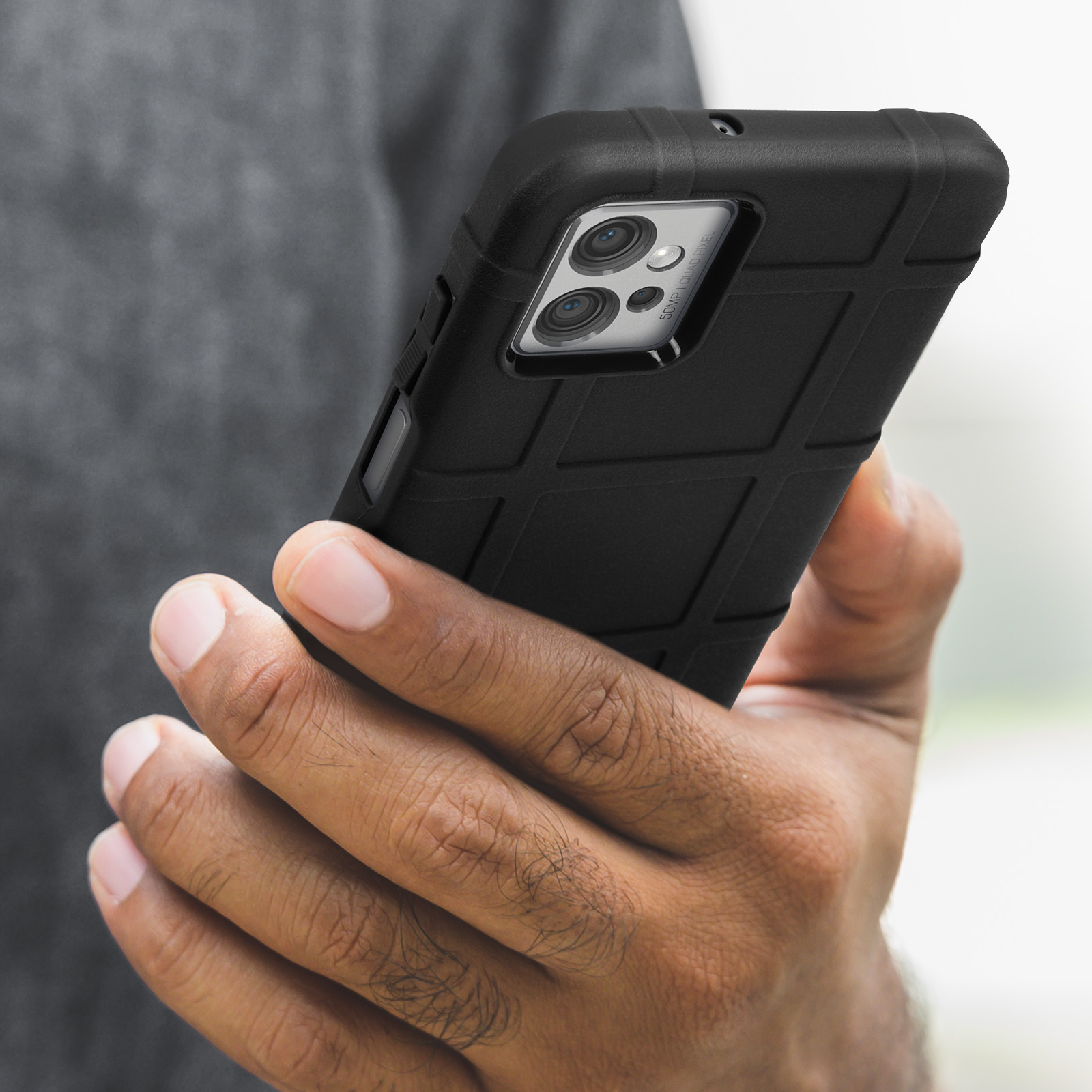 Primo piano di una persona che tiene una custodia nera per telefono con un design strutturato.