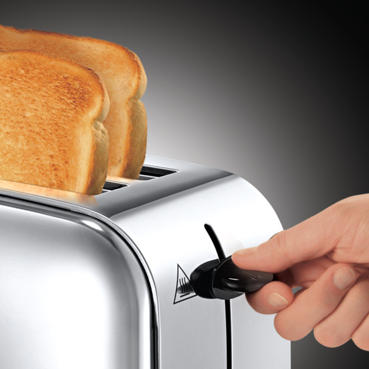 Ein Toaster mit zwei Brotscheiben. Eine Hand stellt den Hebel ein, um das Brot in den Toaster zu senken.