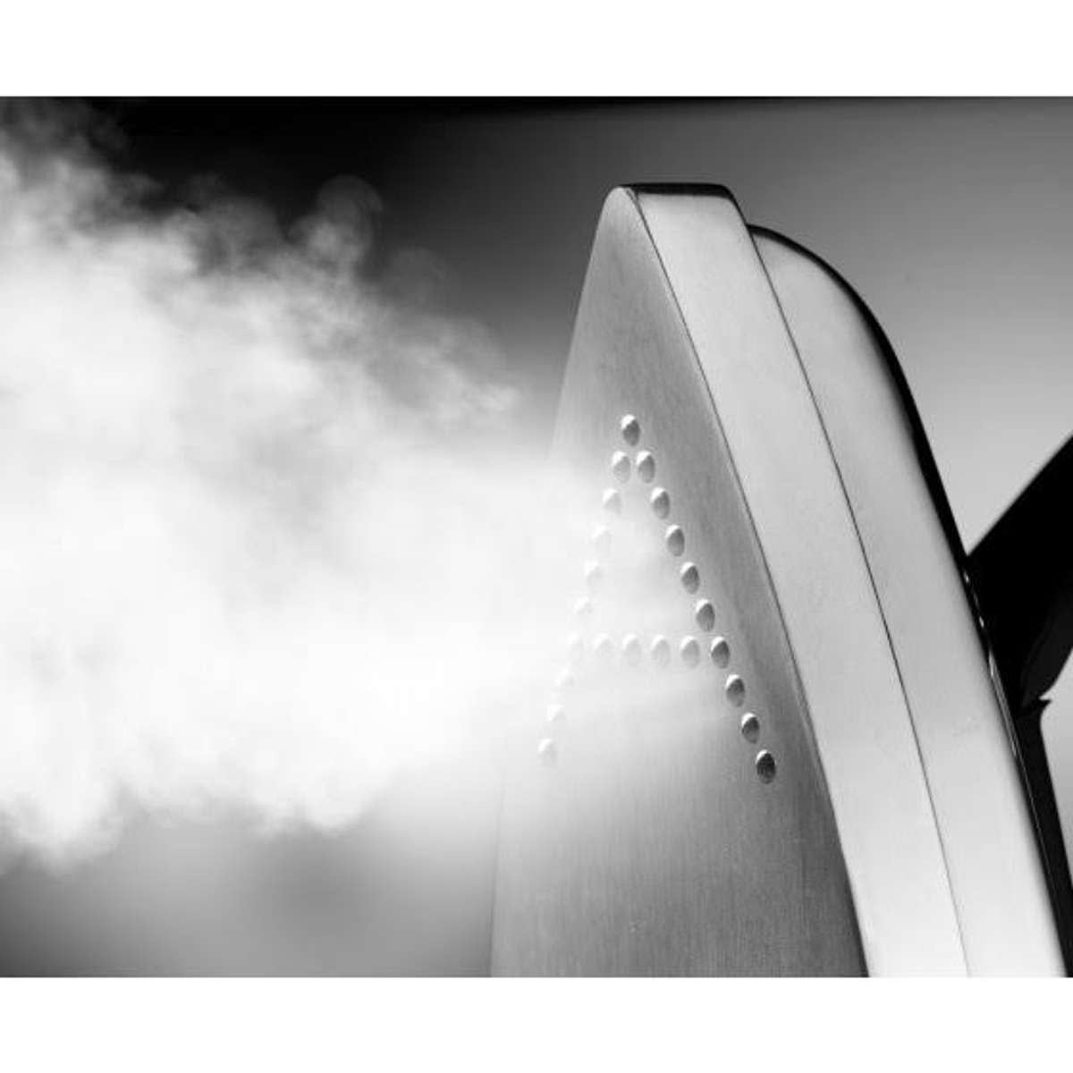 Imagen en blanco y negro de una plancha humeante, inclinada hacia la derecha.