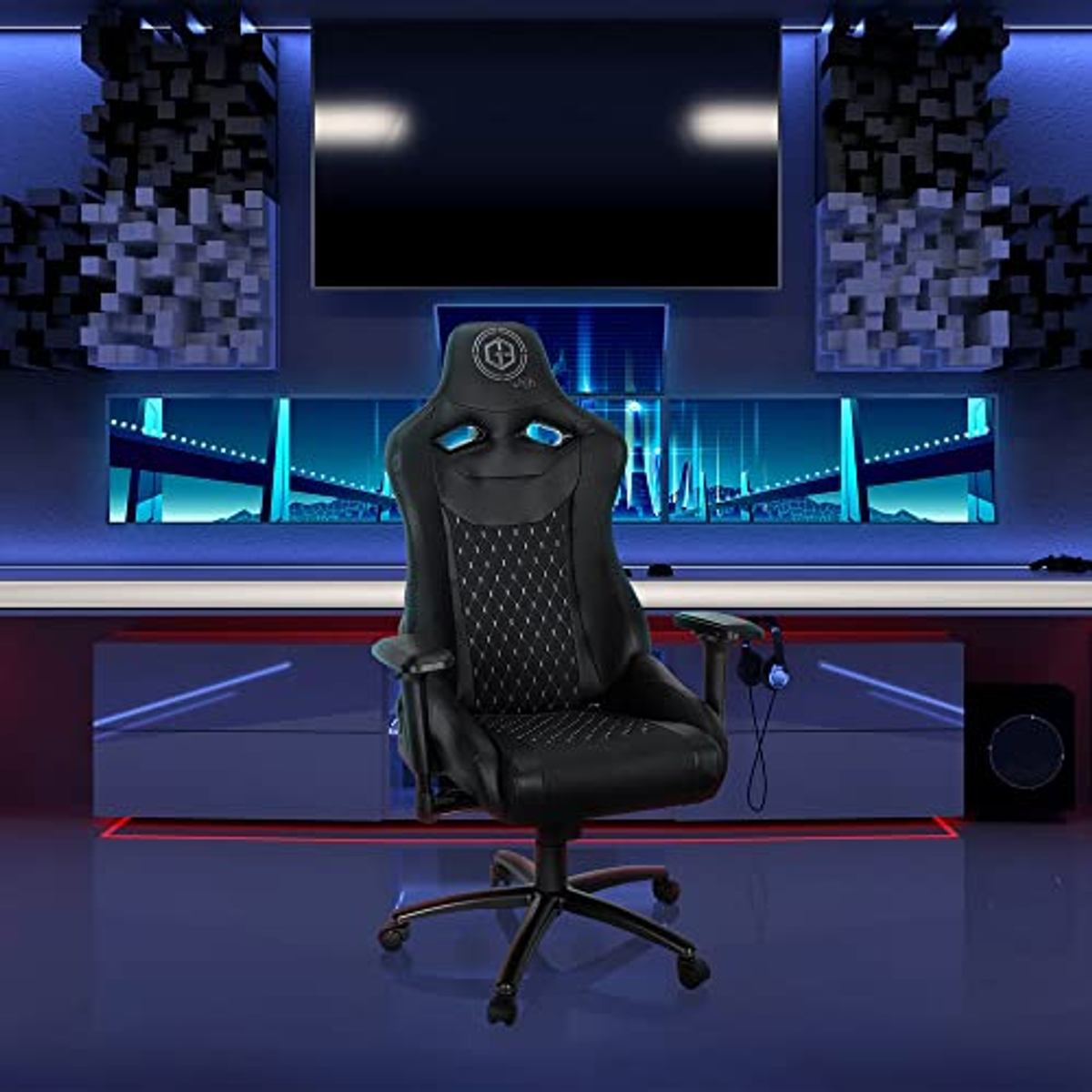 Ein schwarzer Gaming-Stuhl in einem Raum mit blauen Lichtern und einem Fernseher.
