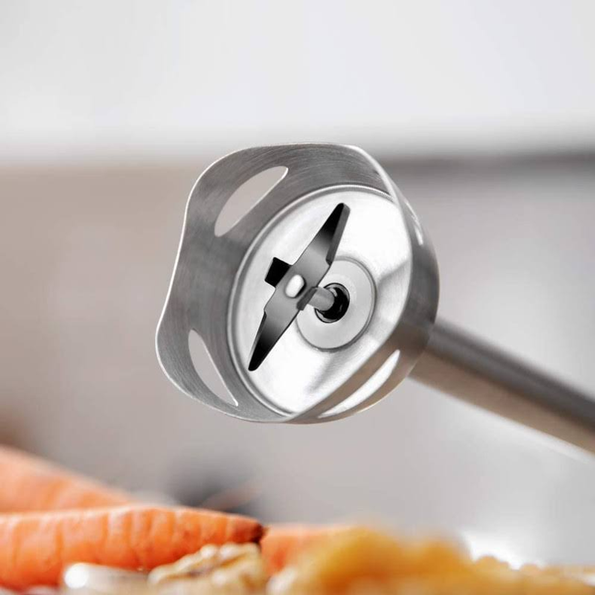 Close-up van een blenderblad, metaal en scherp met wortels op de achtergrond.