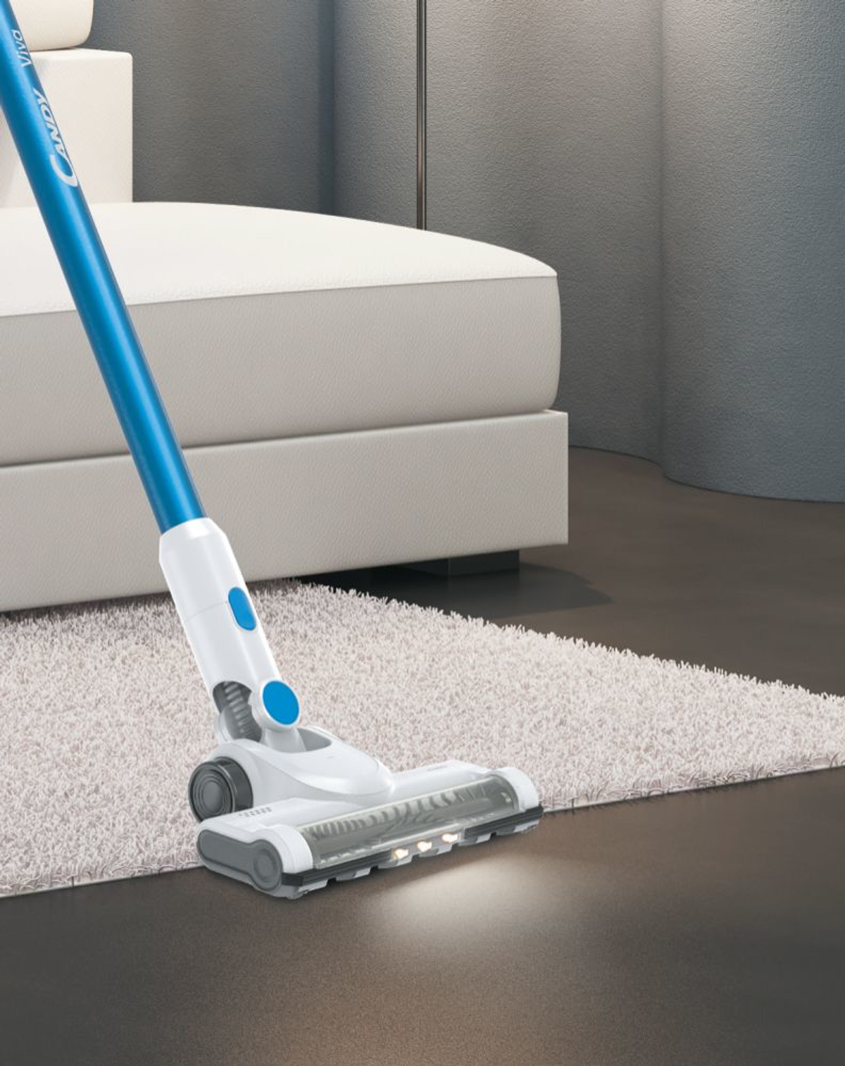 Staubsauger reinigt einen Teppich, im Hintergrund ein weißes Sofa.
