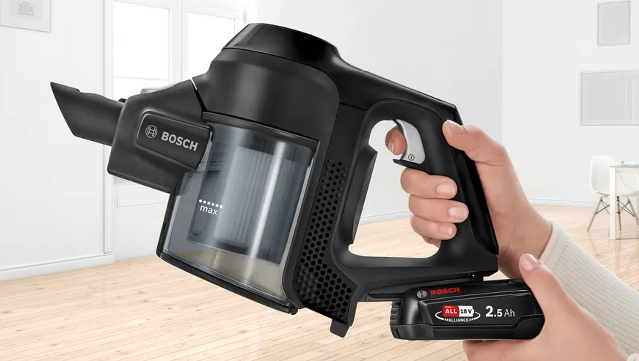 Mano sosteniendo una aspiradora inalámbrica negra; marca Bosch, mostrando la batería y el diseño.