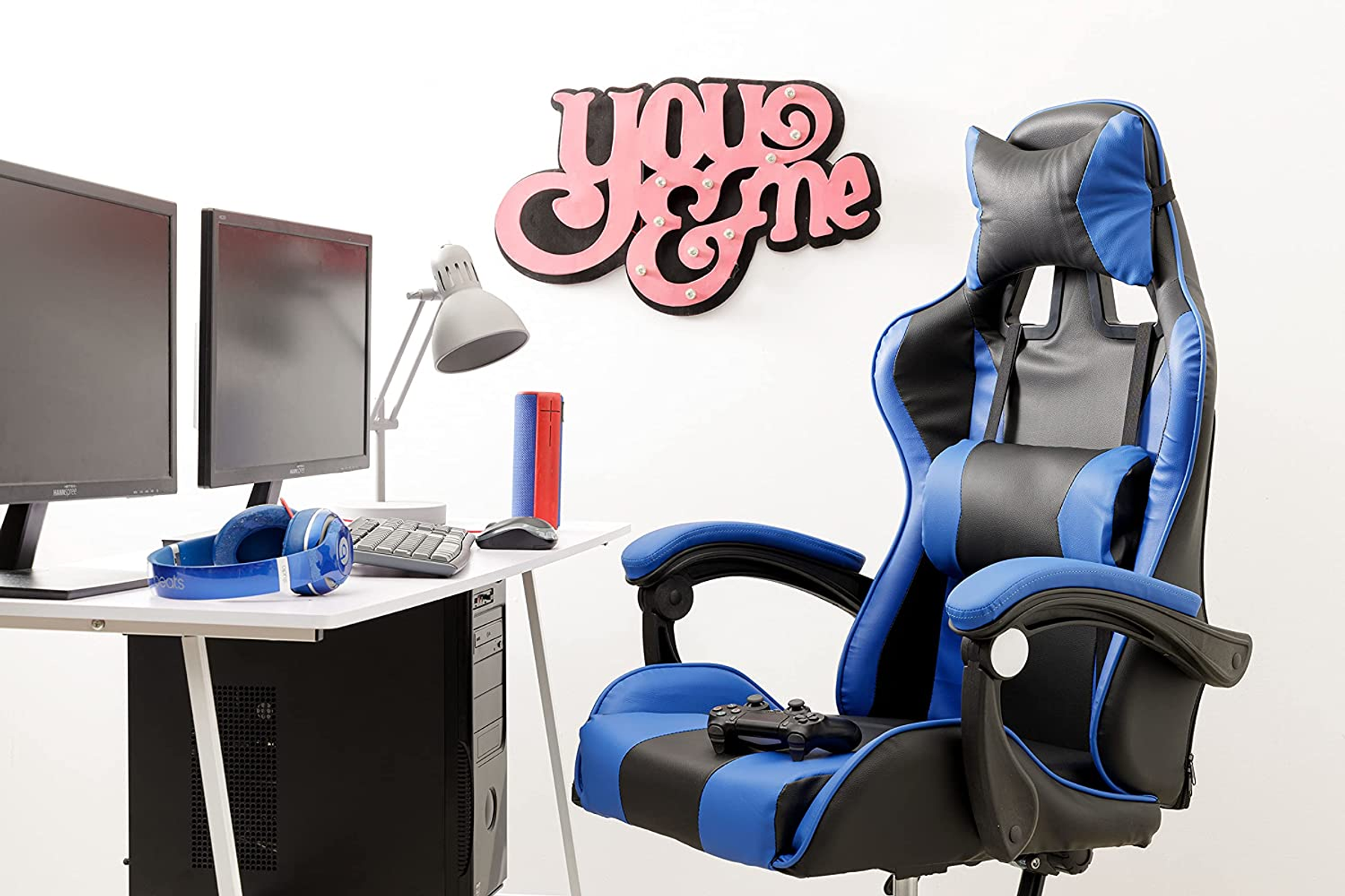 Gaming-Setup mit Monitoren, Kopfhörern, Stuhl, Lautsprechern und einem Schild mit "you & me".