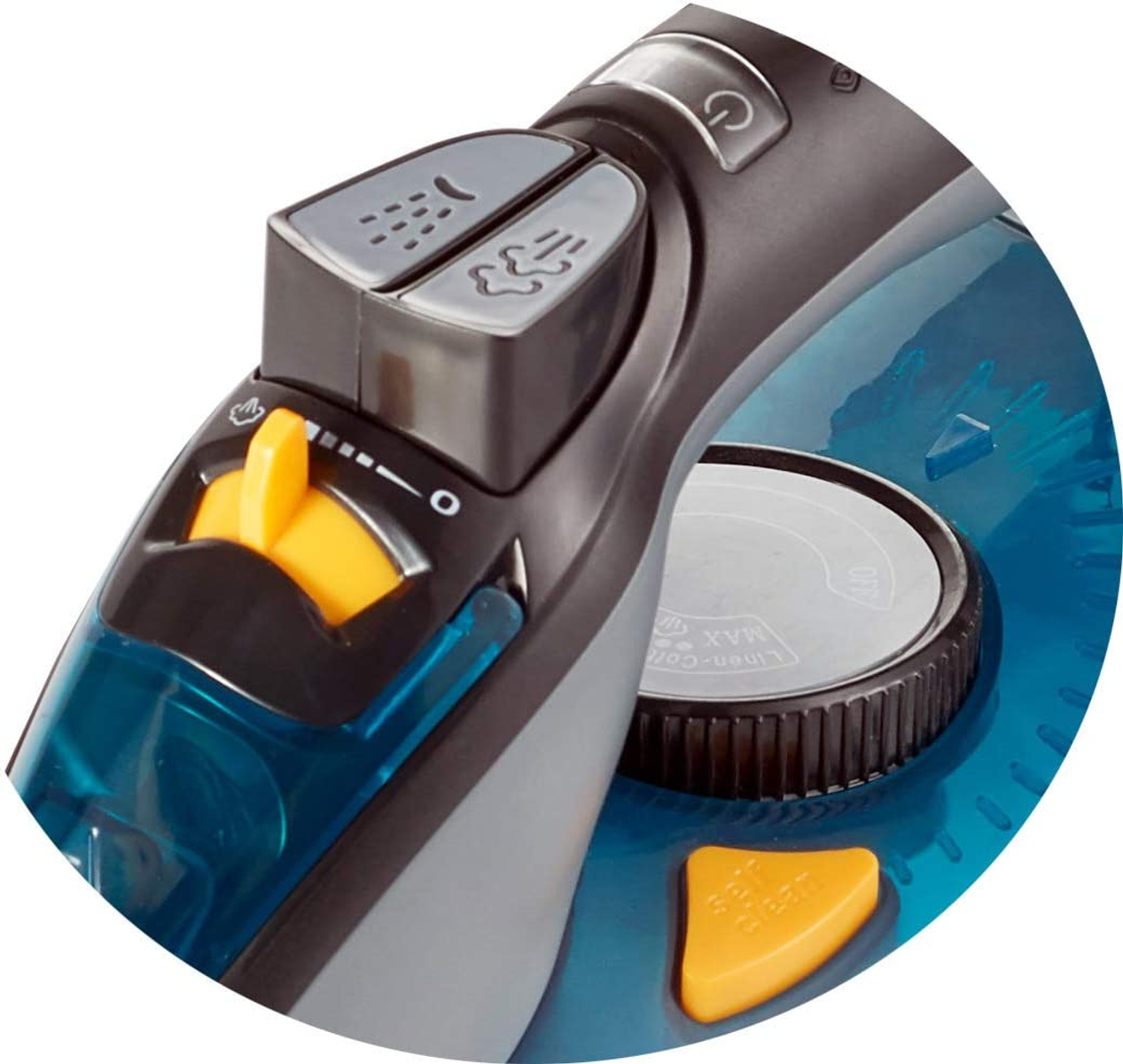 Zbliżenie elementów sterujących żelazka parowego. Żółte pokrętło, szare przyciski i niebieski zbiornik.