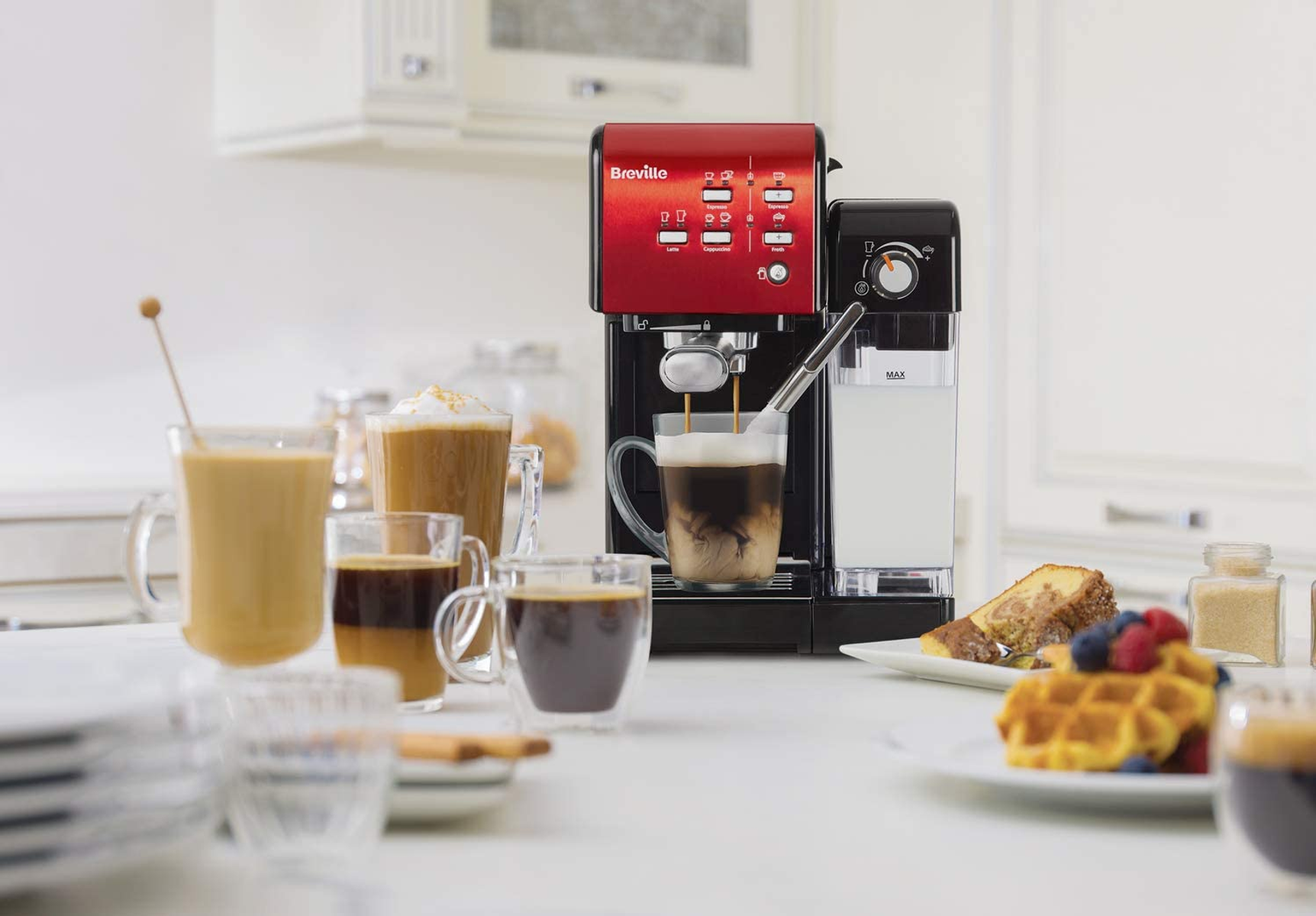 Rote und schwarze Espressomaschine, Kaffee wird gegossen, Kaffee und Gebäck auf Tisch.