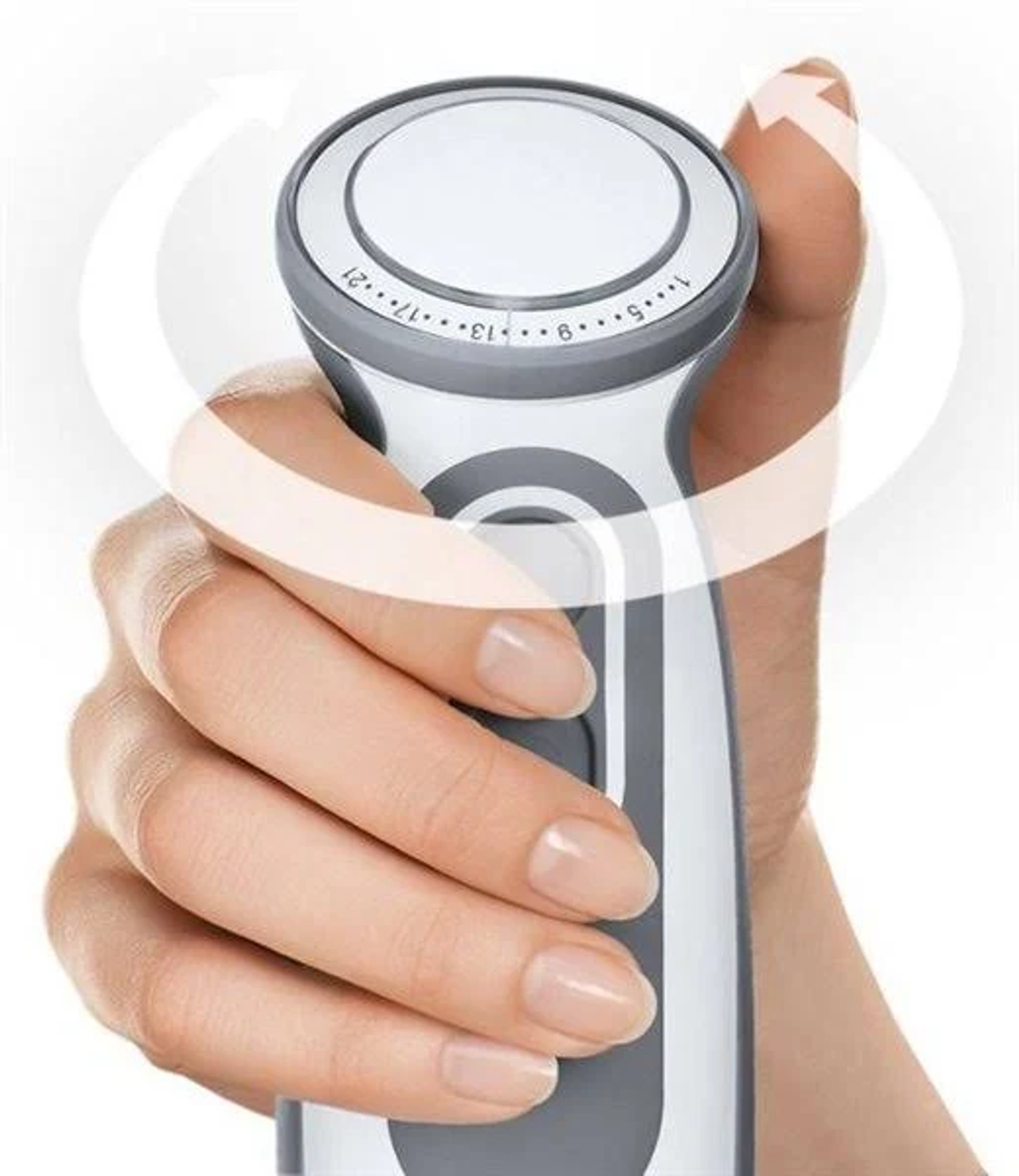Una mano che tiene un frullatore a immersione bianco e grigio, con una freccia rotante. Il frullatore ha un quadrante.