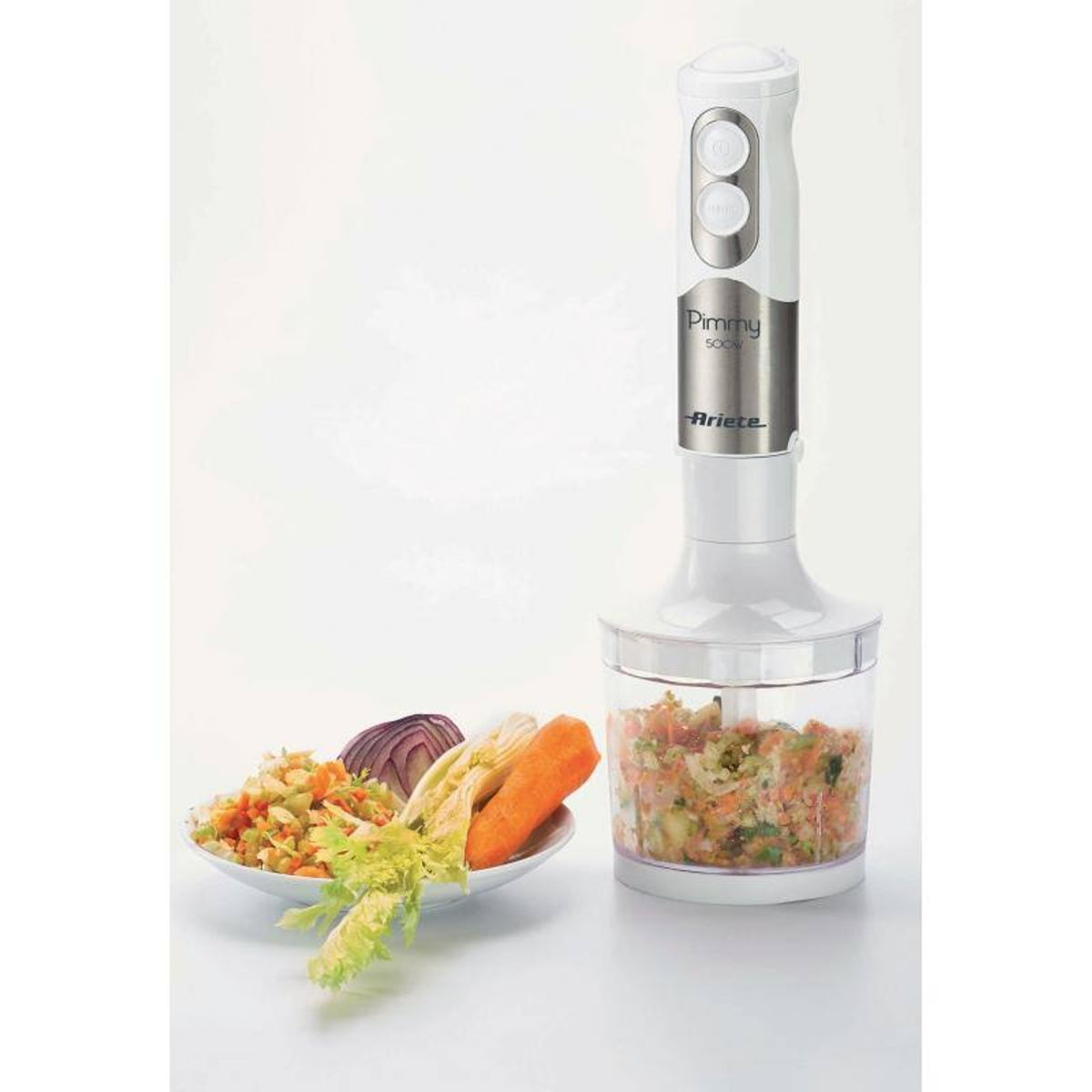 Frullatore a immersione bianco con verdure in contenitore trasparente e verdure tritate.