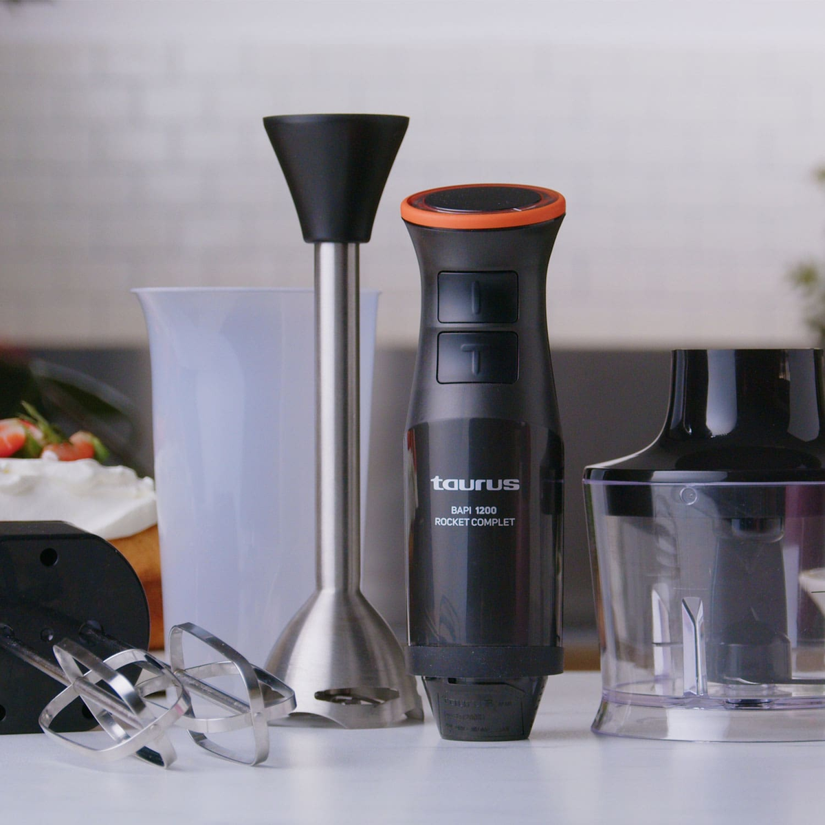 Kilka urządzeń kuchennych na białej powierzchni. Blender, zlewka i ubijacz na pierwszym planie.