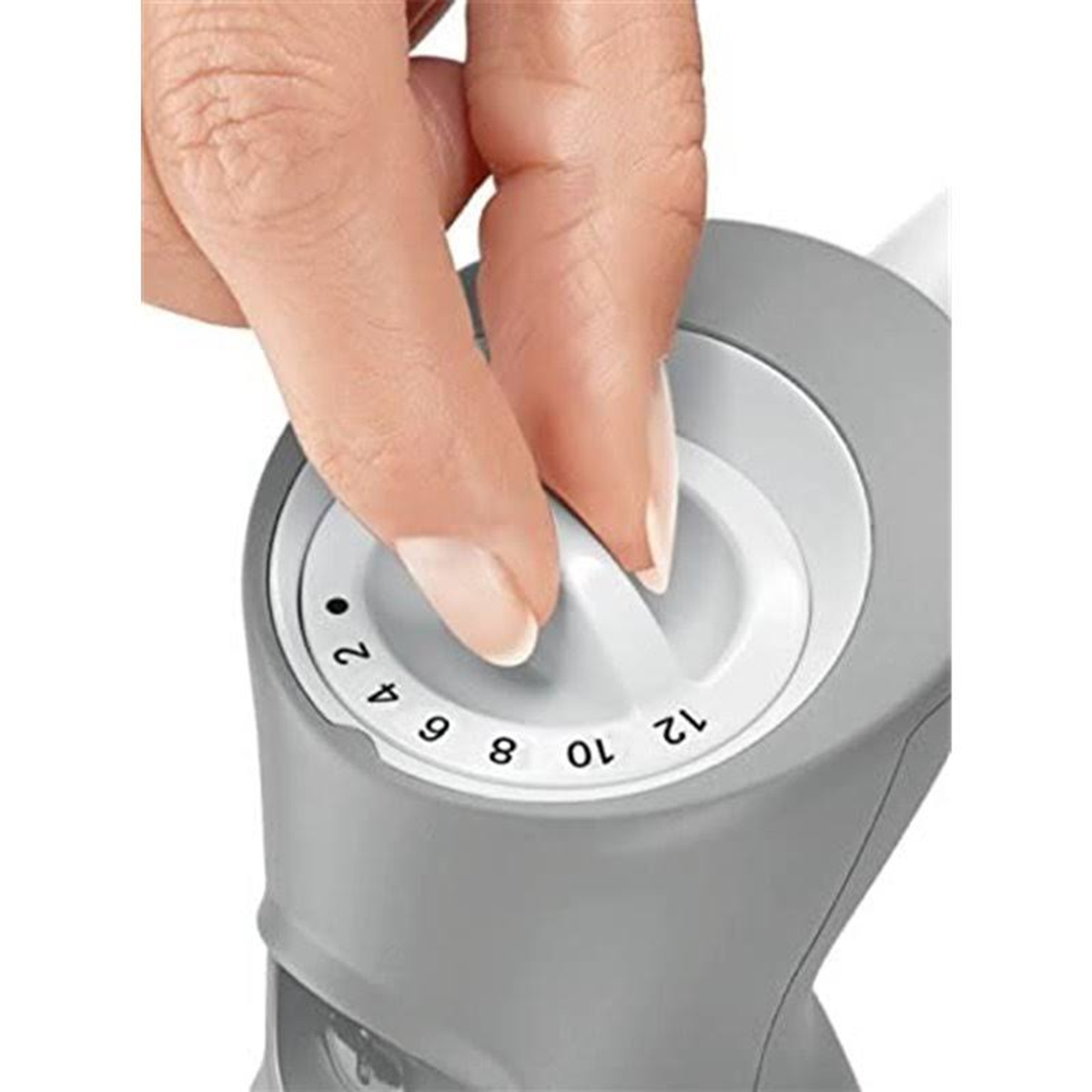 Una mano che gira la manopola su un apparecchio grigio, con i numeri 2, 4, 6, 8, 10 e 12 visibili.