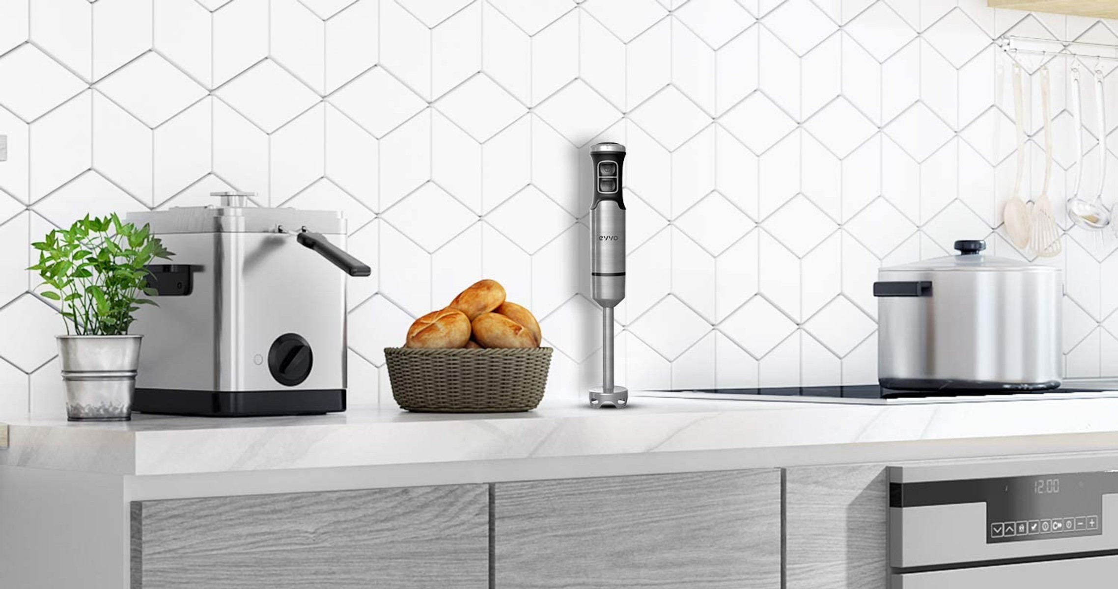 Encimera de cocina con electrodomésticos: una freidora, una cesta de pan, una batidora, una sartén y una estufa.