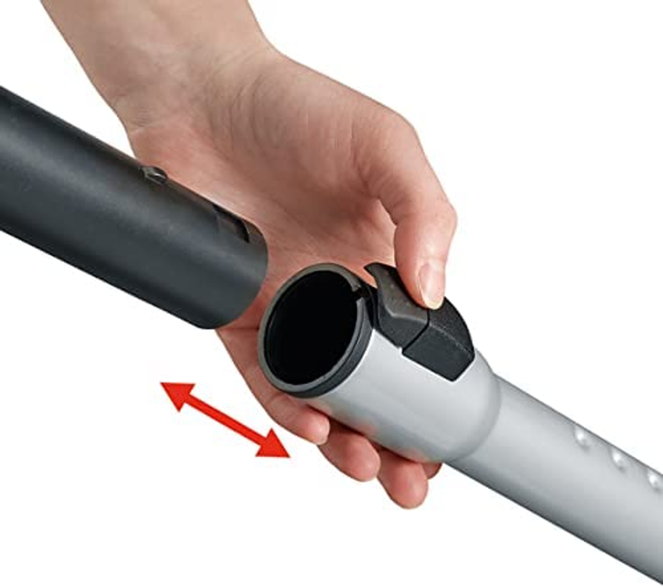 Dłoń łącząca części odkurzacza, czerwona strzałka, szary i czarny.