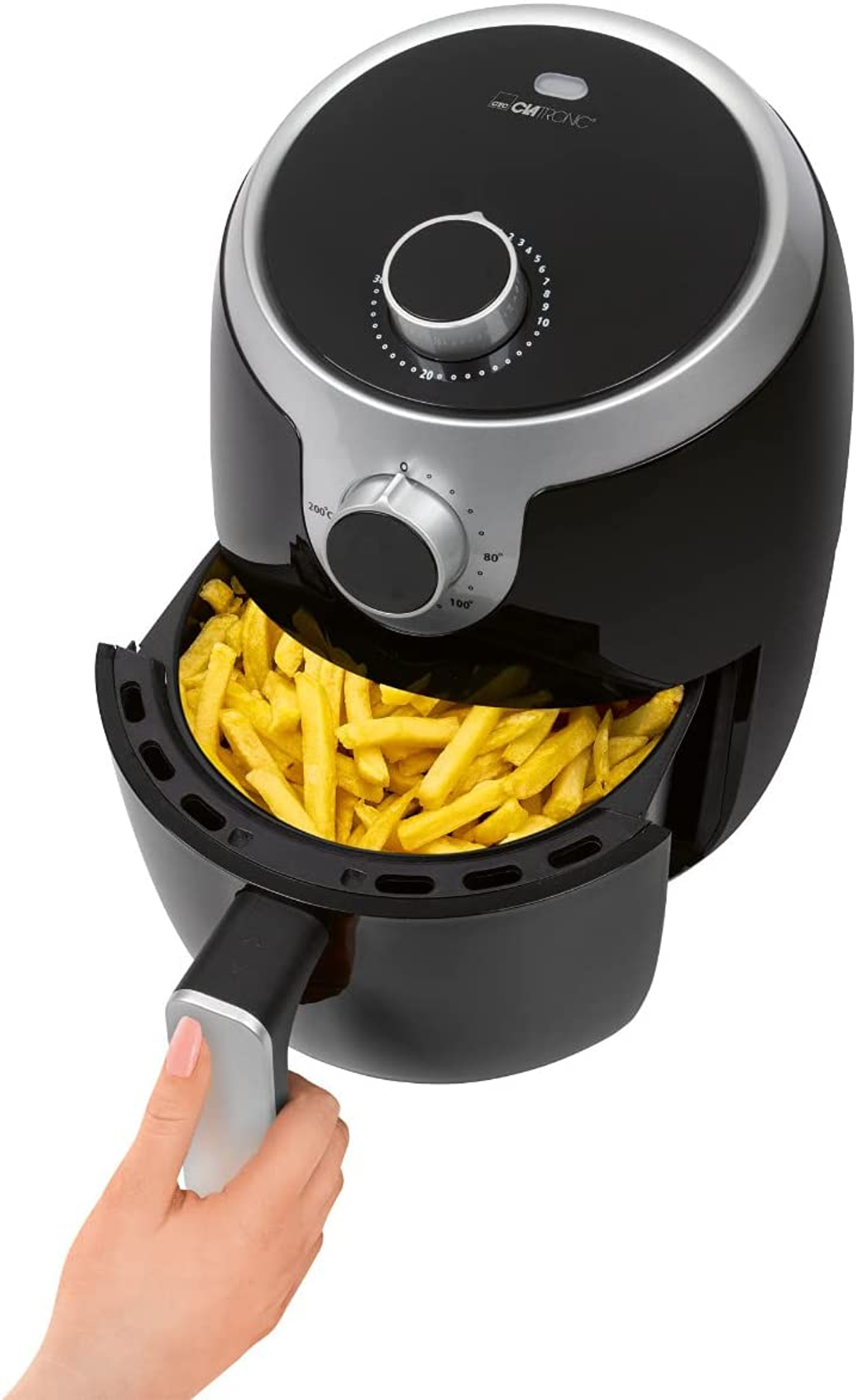 Otwarta frytkownica powietrzna z frytkami w środku. Ręka sięga po uchwyt.