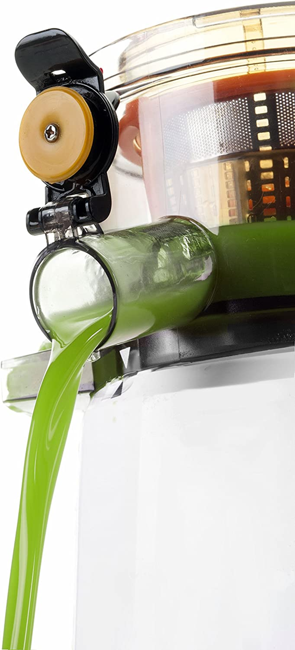 Una exprimidora con jugo verde saliendo. El jugo fluye hacia un recipiente blanco, con una boquilla transparente.