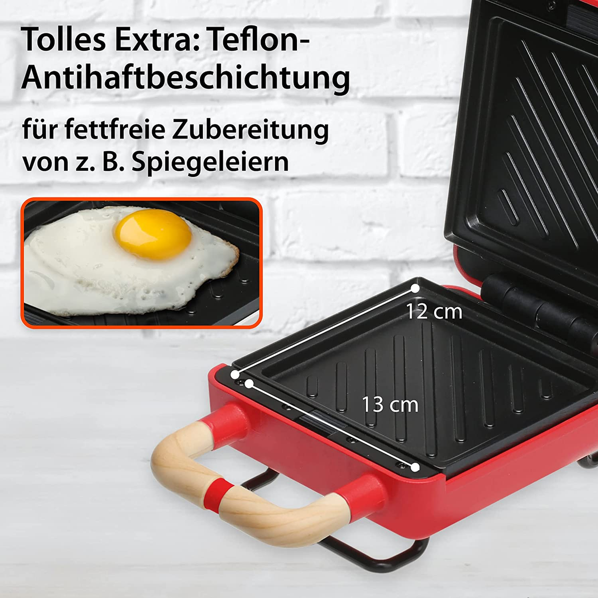 Czerwona i czarna opiekacz do kanapek z otwartą pokrywą i jajkiem sadzonym.