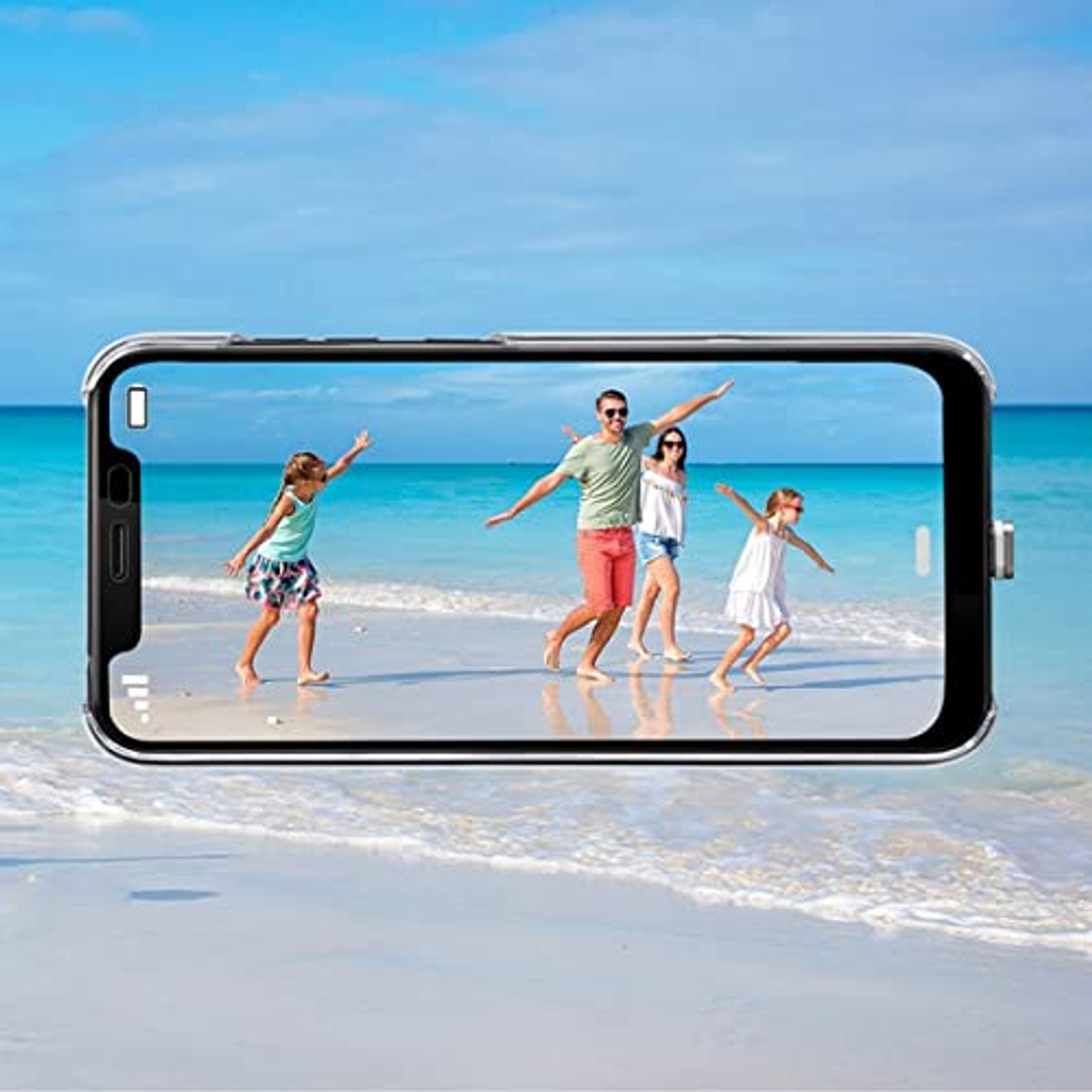 Rodzina na plaży, oglądana przez ekran telefonu. W tle ocean i błękitne niebo.