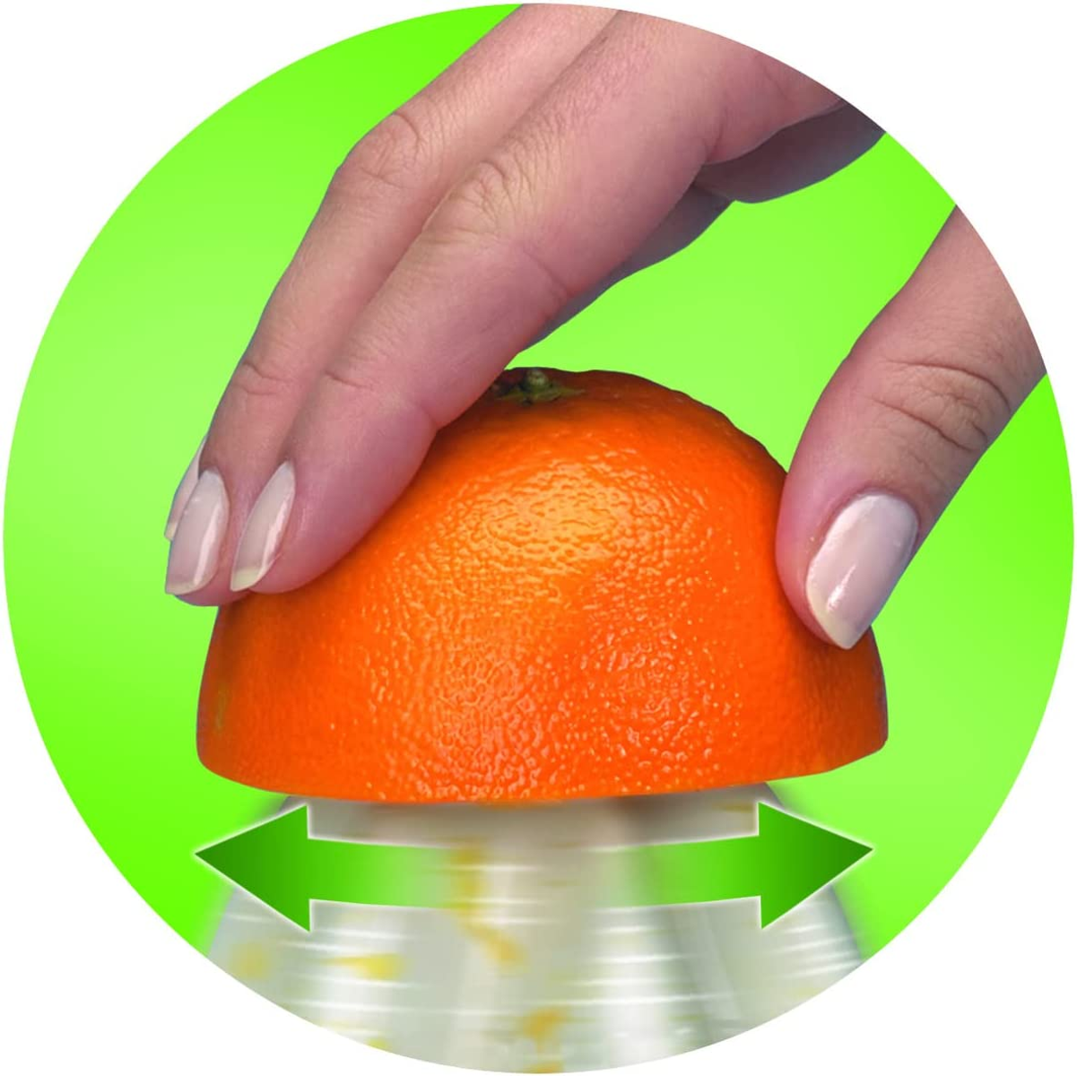 Eine Hand presst eine Orangenhälfte, um Saft in eine Saftpresse zu extrahieren. Grüner Hintergrund.