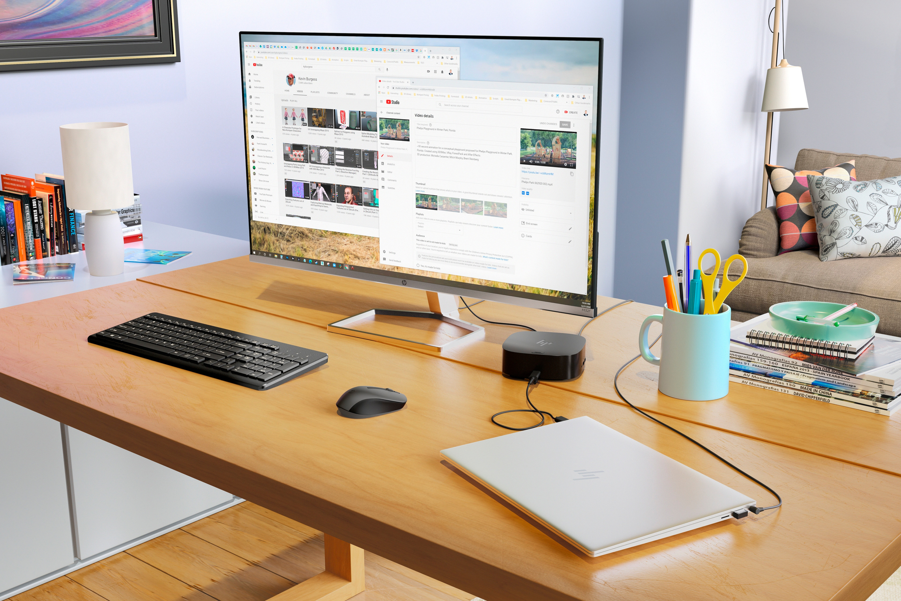 Un setup da scrivania con un monitor che mostra YouTube. Tastiera, mouse, laptop e accessori da scrivania sono presenti.