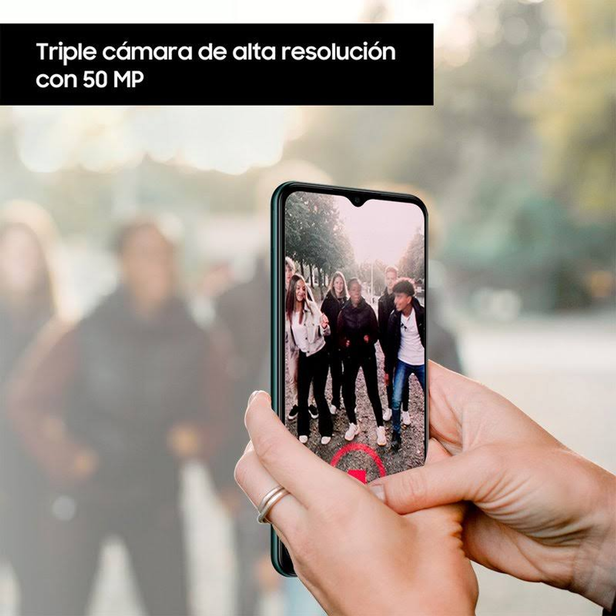 Persona tiene telefono che filma un gruppo, testo: Tripla fotocamera con 50 MP.