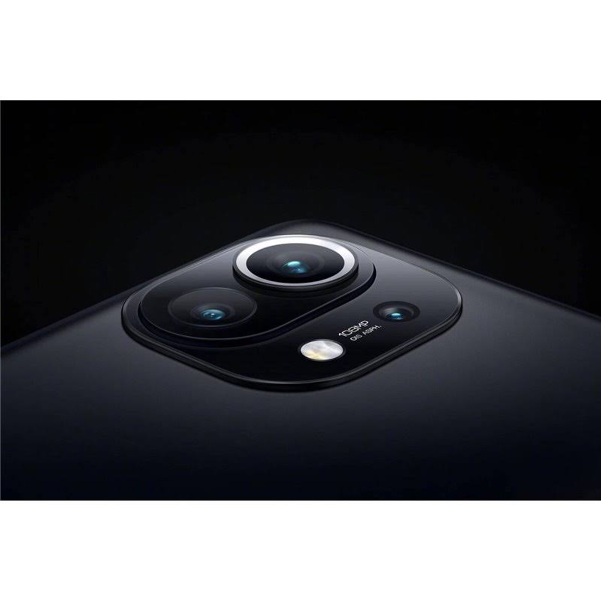 Modulo fotocamera di un telefono nero con tre lenti e un flash su una superficie nera.