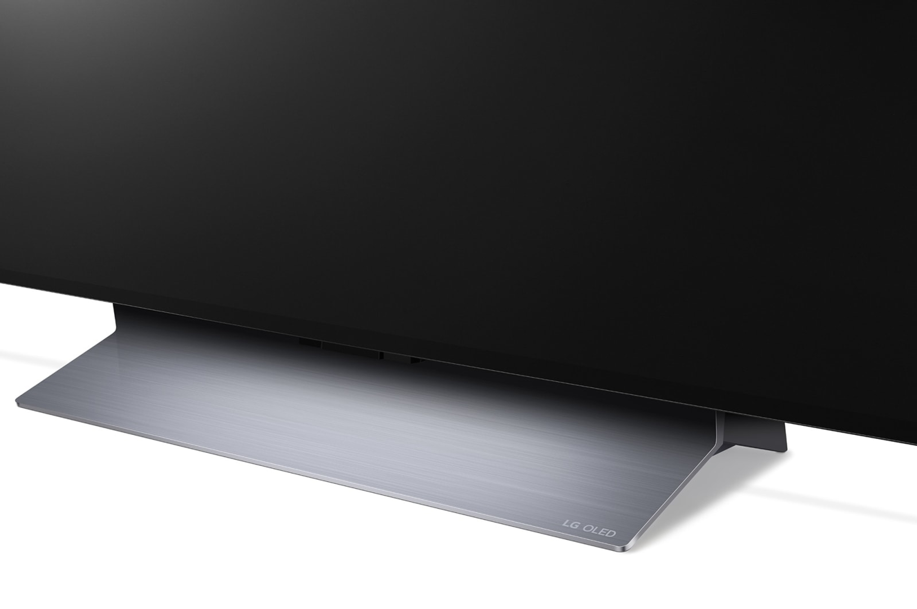 Primer plano de una base de TV, logo LG OLED visible. Base plateada, metálica. Fondo blanco.