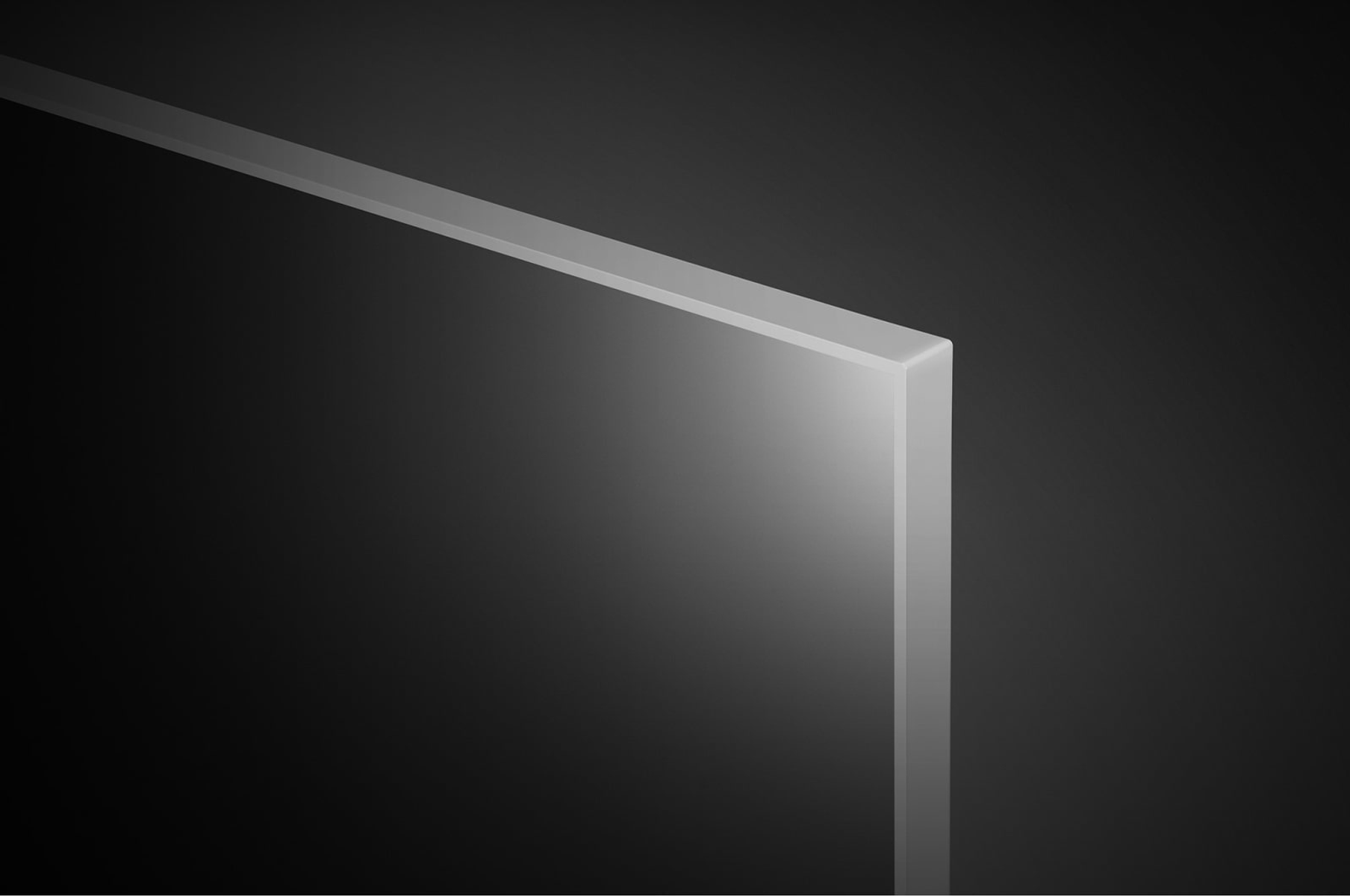 Zbliżenie rogu telewizora. Róg jest szary, z jasnym światłem na krawędzi.