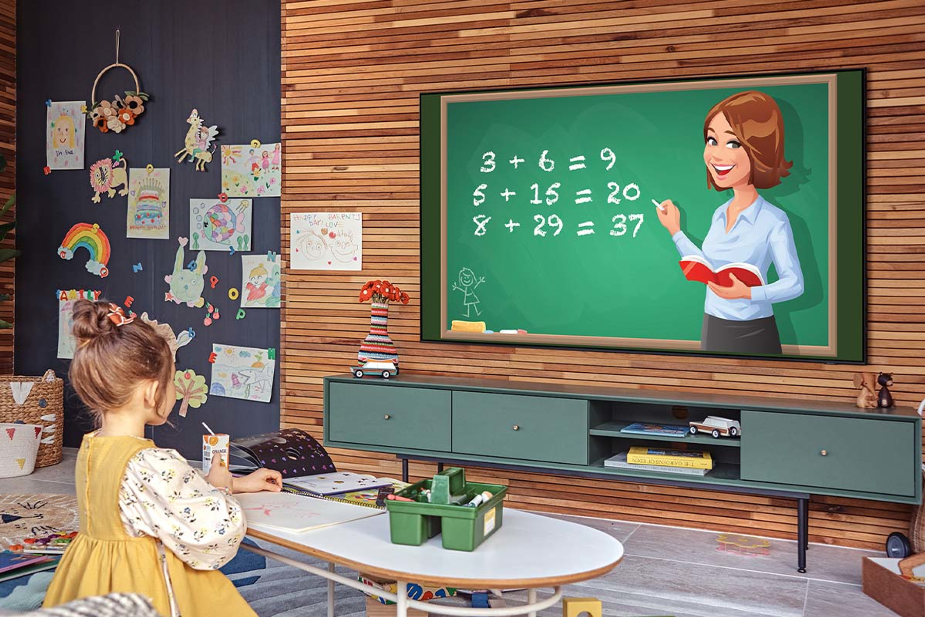 Dziewczynka ogląda nauczycielkę w TV. Nauczycielka pokazuje matematykę.