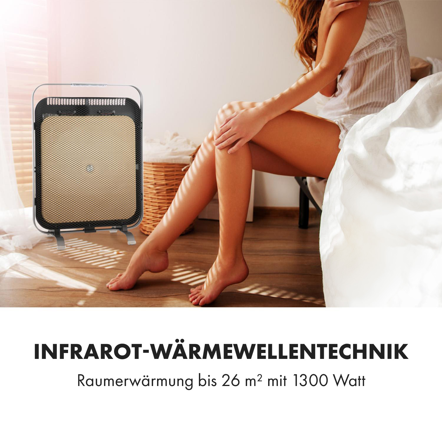 Eine Frau sitzt in der Nähe eines Infrarot-Heizgeräts. Das Heizgerät ist schwarz-gold und hat eine Gitterfront.