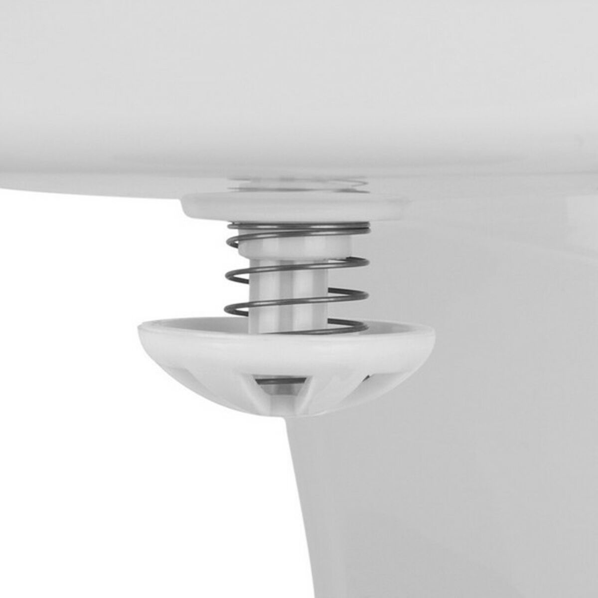 Biały plastikowy element urządzenia, sprężyna i część w kształcie stożka na pierwszym planie.