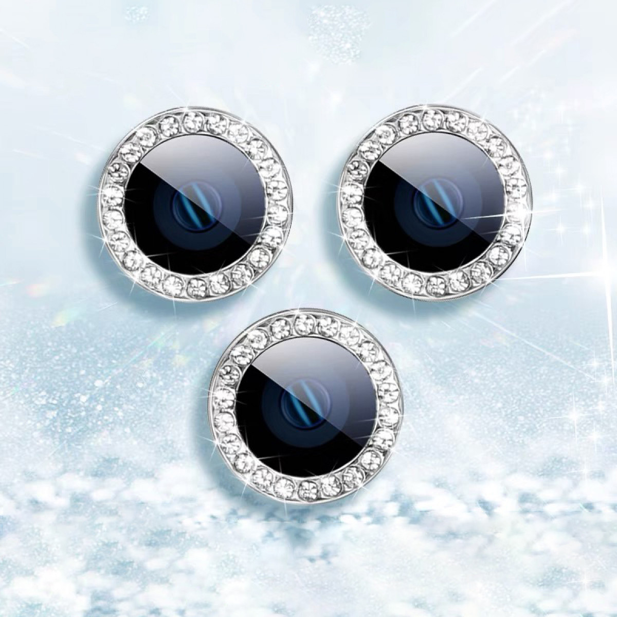 Drie cameralenzen met diamantachtige ringen op een lichtblauwe, sprankelende achtergrond.