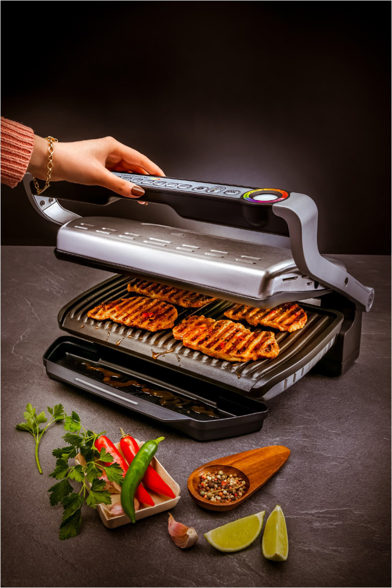 Eine Person grillt Fleisch auf einem Grill. Enthält Gemüse und Gewürze sowie den Grill.