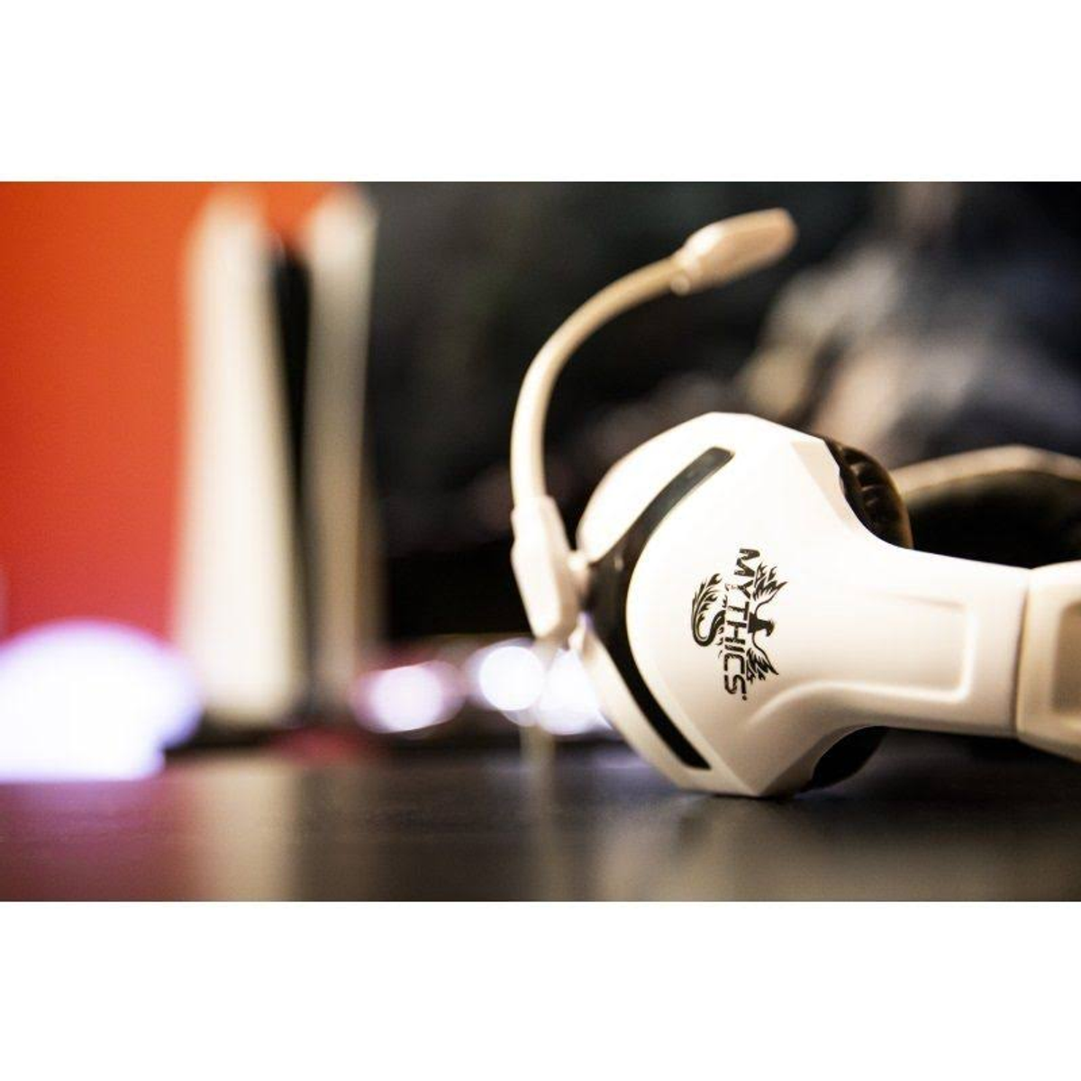 Biały zestaw słuchawkowy dla graczy z mikrofonem na ciemnej powierzchni, rozmyte tło.