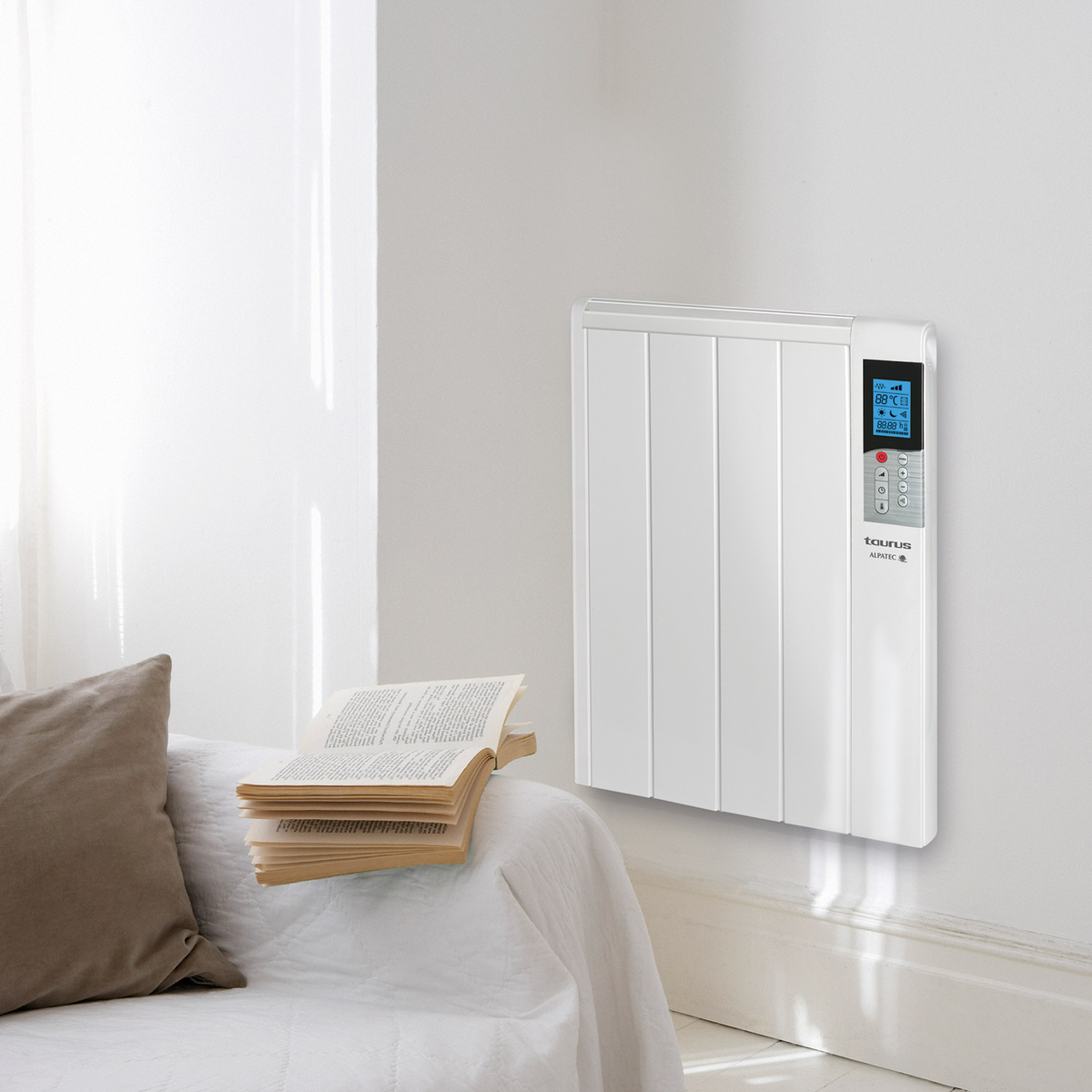 Un calefactor eléctrico blanco montado en una pared blanca, cerca de una cama con un libro encima.