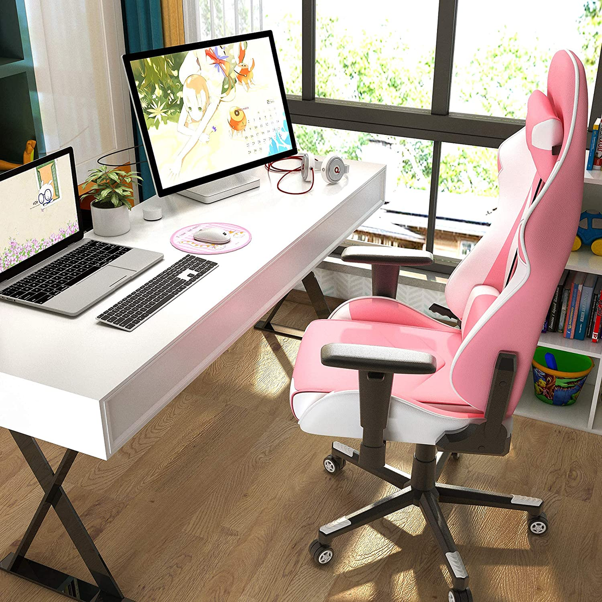 Ein Schreibtisch mit Computer-Setup, einschließlich eines rosa Gaming-Stuhls.