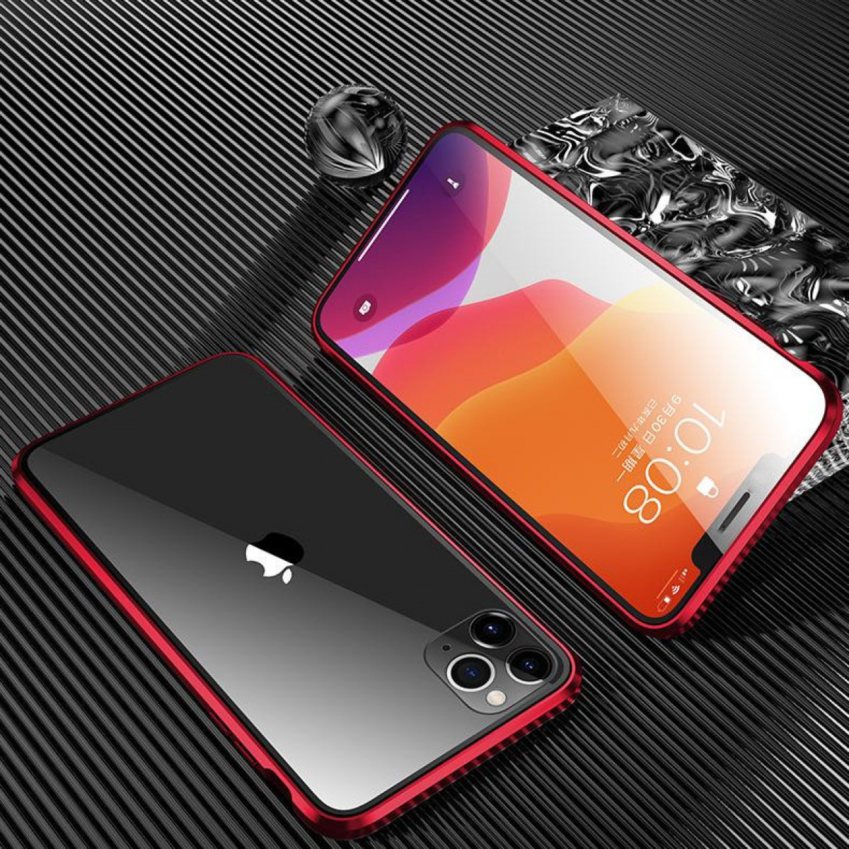 Zwei Telefone, eines schwarz und eines rot, liegen auf einer Oberfläche. Das rote hat einen Rahmen.