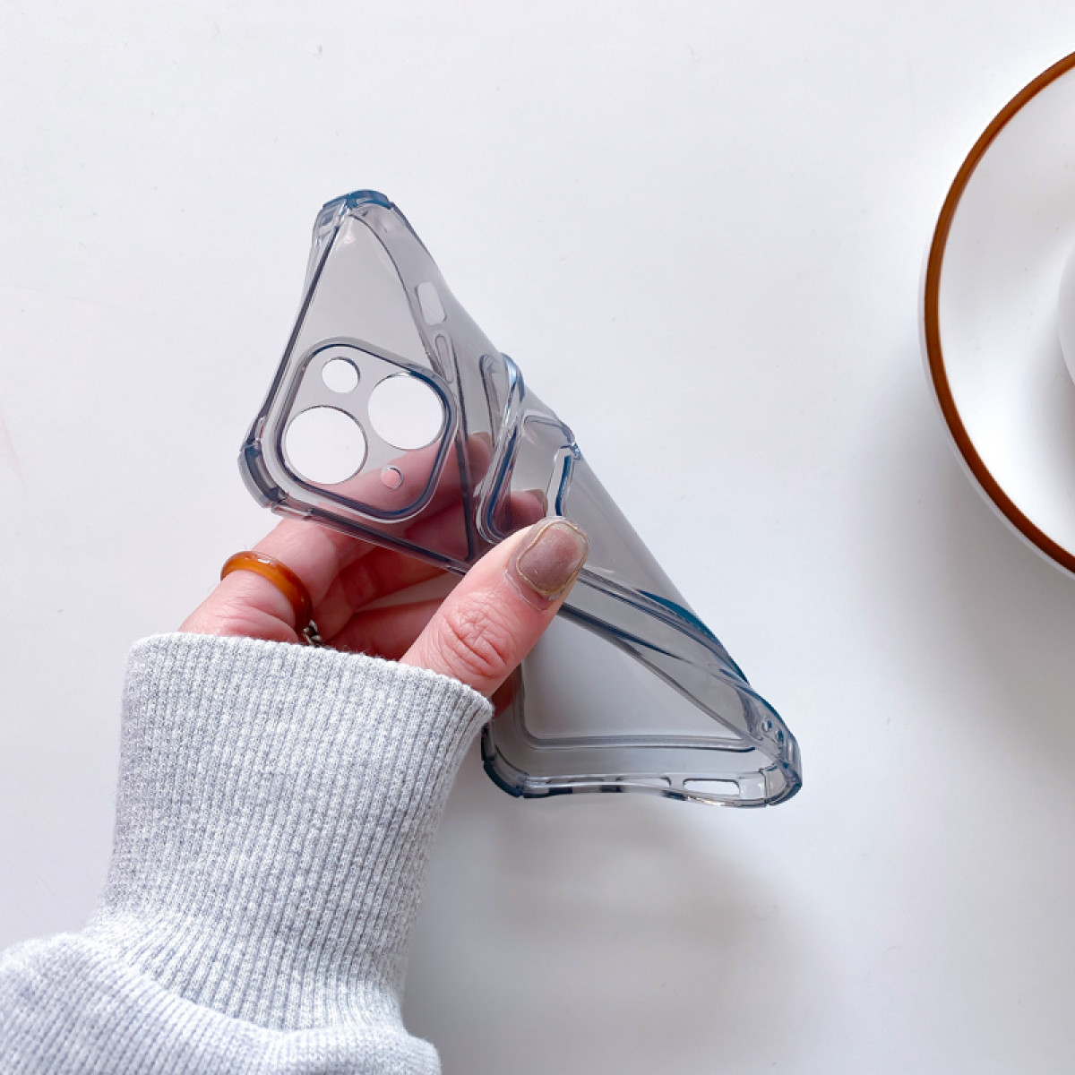 Hand hält eine transparente Handyhülle. Die Hülle ist transparent und schützt das Telefongehäuse.