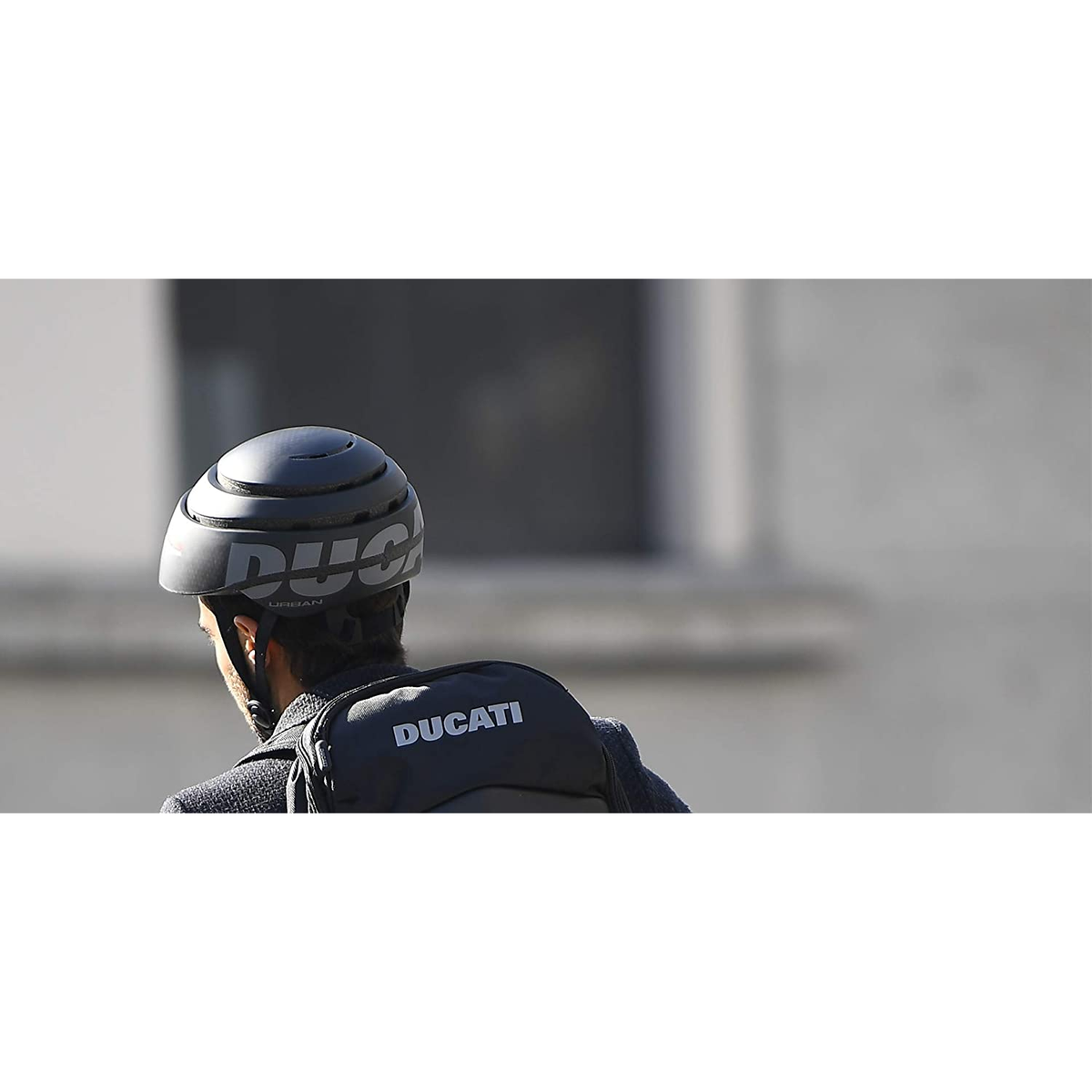 Una persona que lleva un casco Ducati negro y una mochila.
