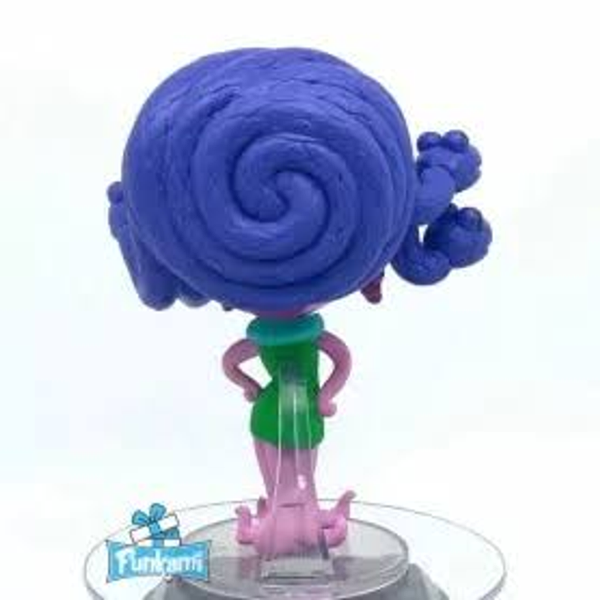 Figura de un personaje con pelo azul y vestido verde. Piernas rosas, brazos en las caderas. Base transparente.