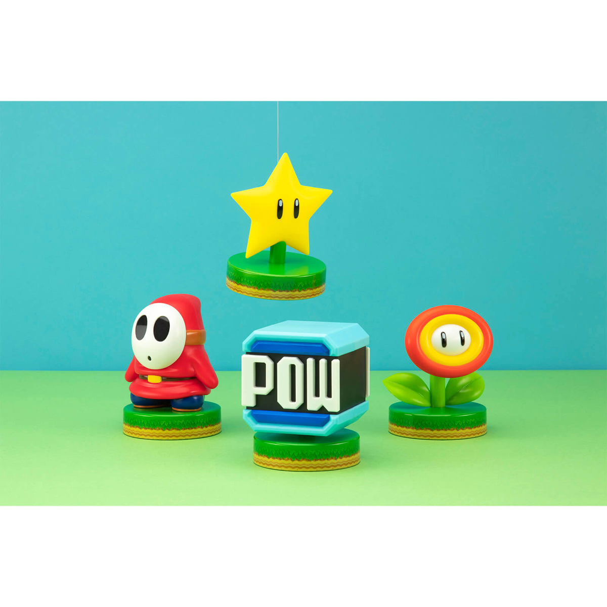 Vier Super Mario-Figuren: Stern, Shy Guy, POW-Block und Feuerblume.