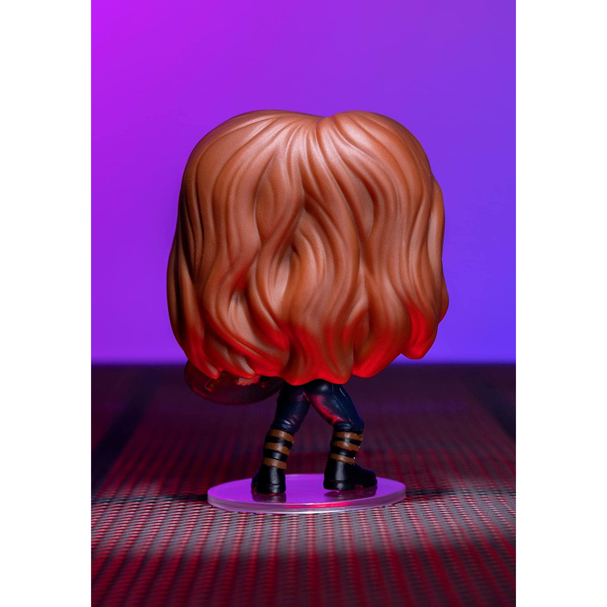 Figura Funko Pop di una donna con capelli lunghi, stivali neri e pantaloni a righe.