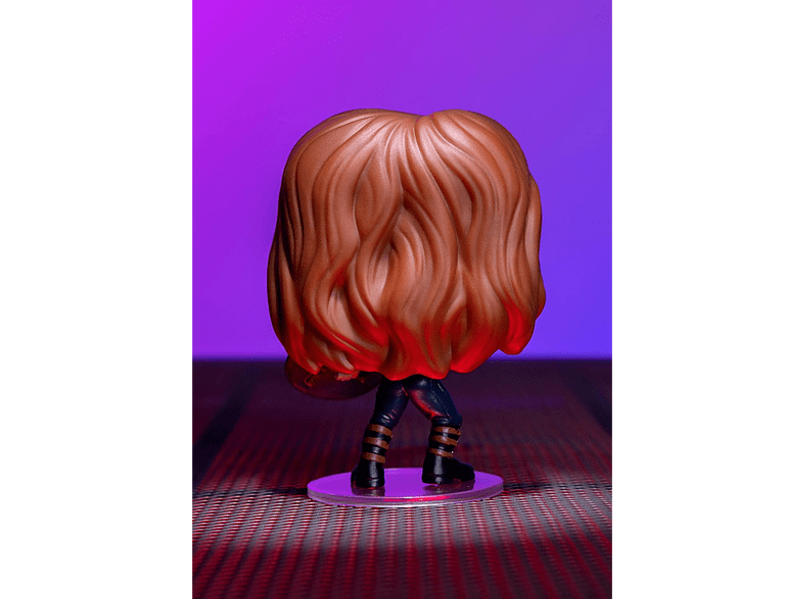 Vista posteriore della figura Chucky Funko Pop. Capelli castani, abito nero e supporto trasparente.