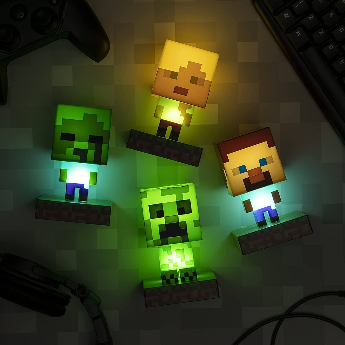 Lámparas de personajes de Minecraft: Steve, Zombi, Creeper y otro Steve, todos brillando.
