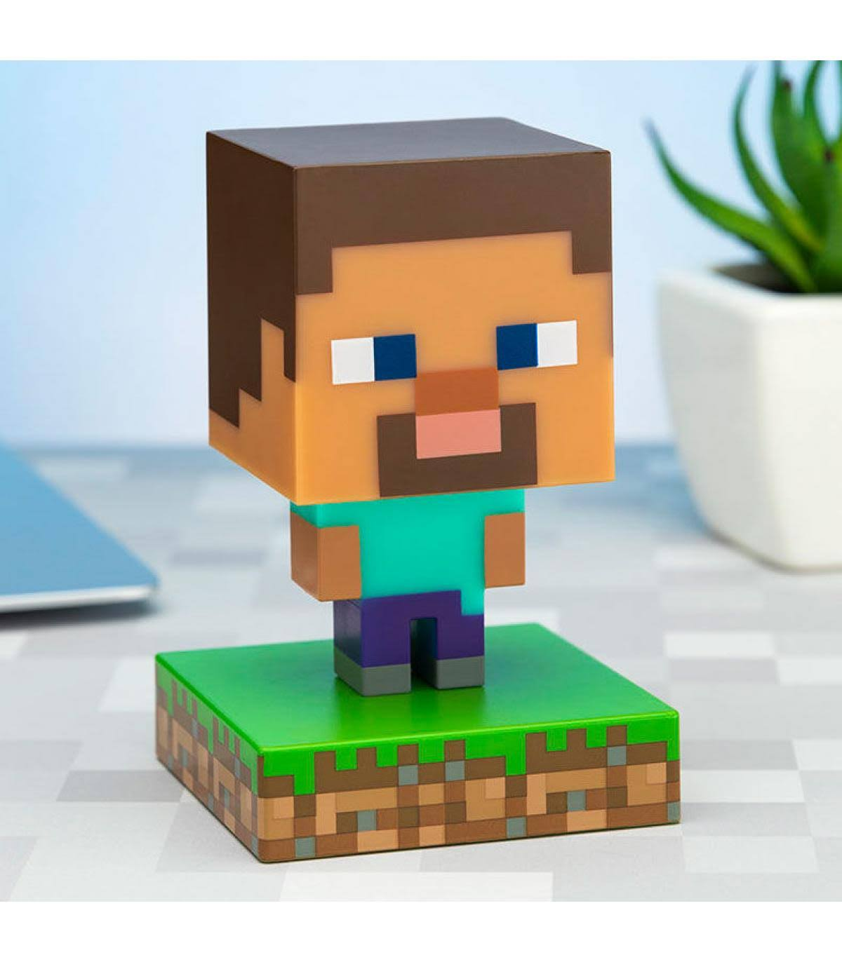 Una figura de Steve de Minecraft. Steve es un personaje en bloques sobre una base en bloques verde y marrón.