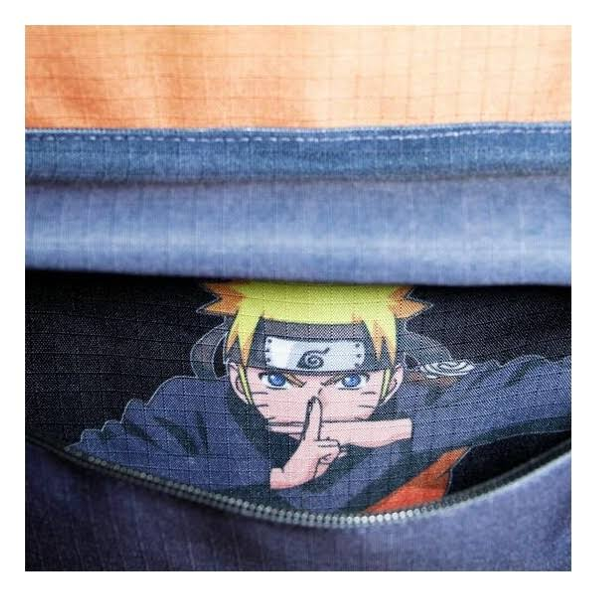 Nahaufnahme einer Naruto-Figur aus der Naruto-Anime-Serie, die aus einer blauen Tasche herauslugt.