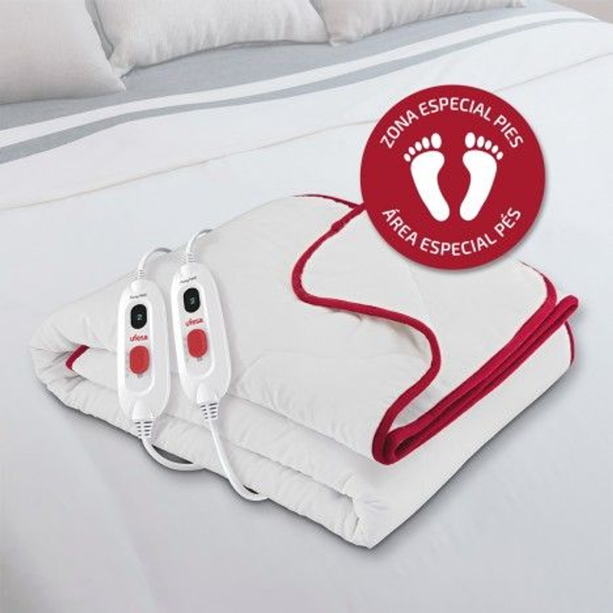 Manta térmica blanca en la cama. Borde rojo. Paneles de control visibles. Icono de zona de pies.
