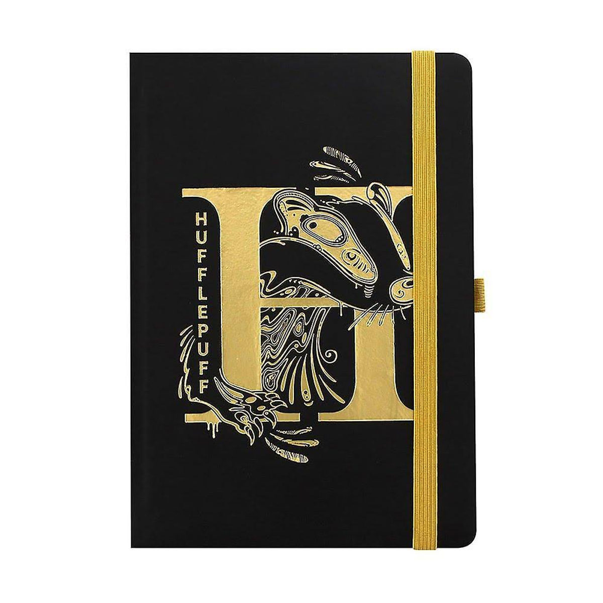 Schwarzes Notizbuch. Goldenes Hufflepuff-Emblem und Text. Gelbes Gummiband.