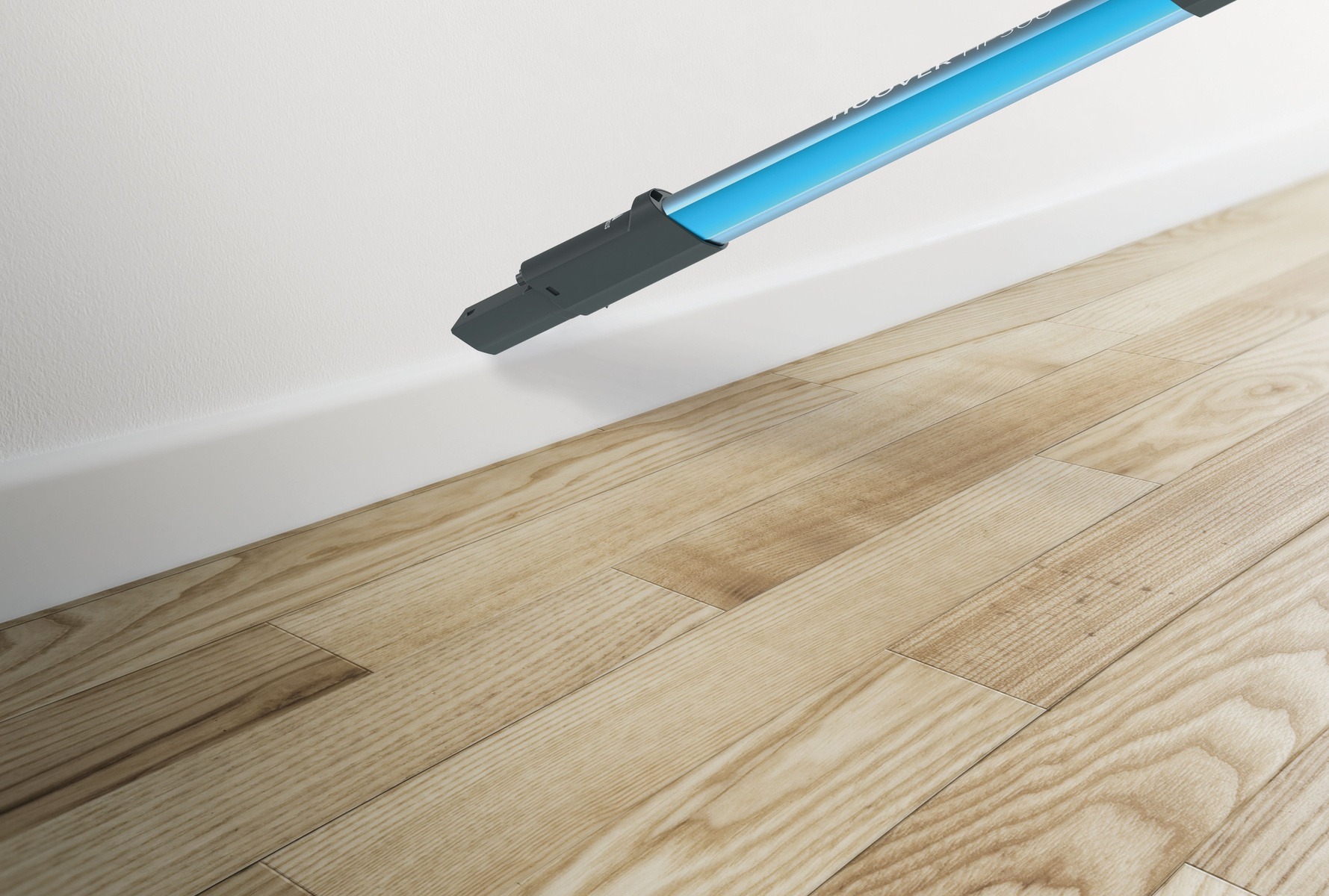 Herramienta de limpieza colocada en un piso de madera cerca de la pared blanca. La herramienta es azul y gris.