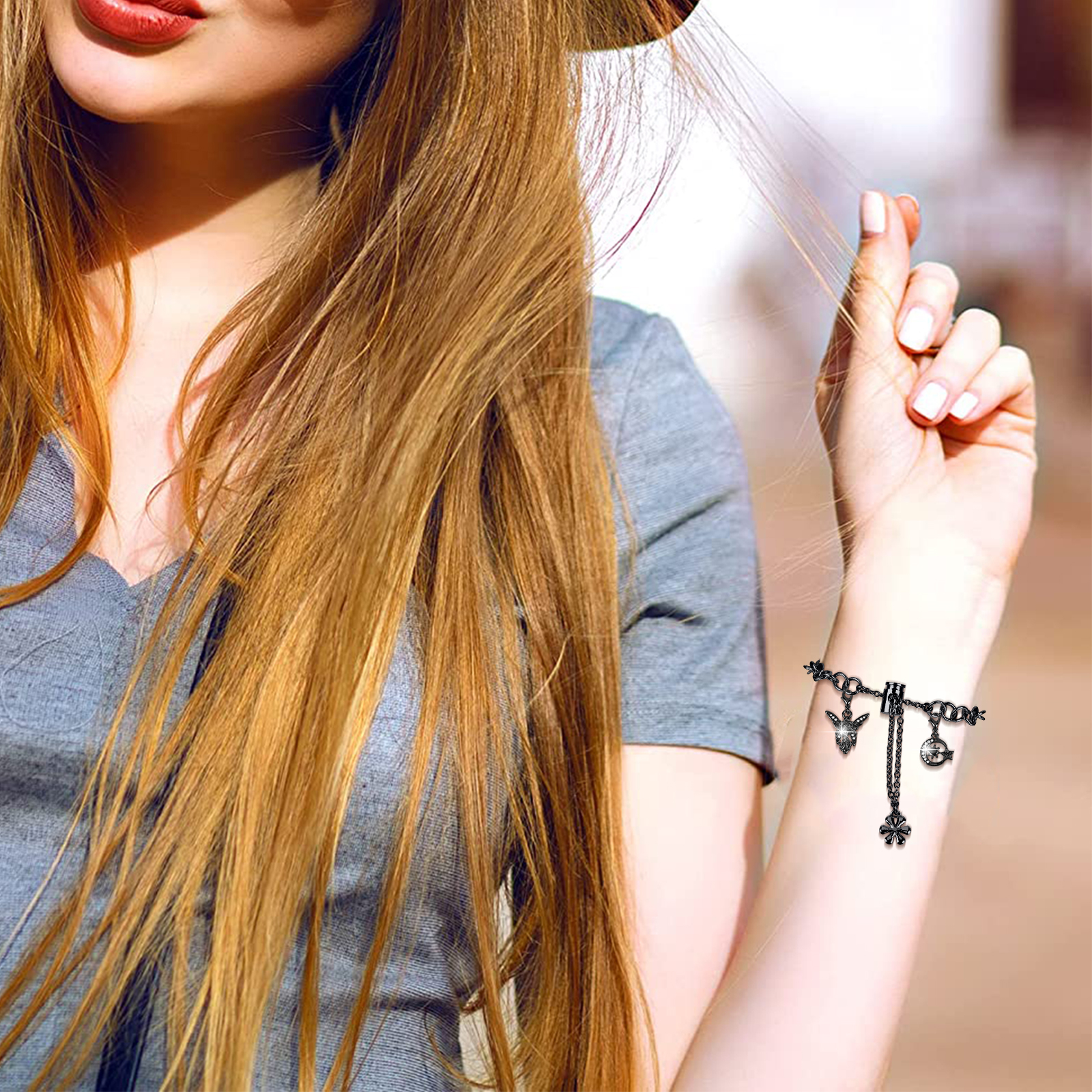 Eine Frau mit langen, hellbraunen Haaren hält ein Armband an ihrem Handgelenk.