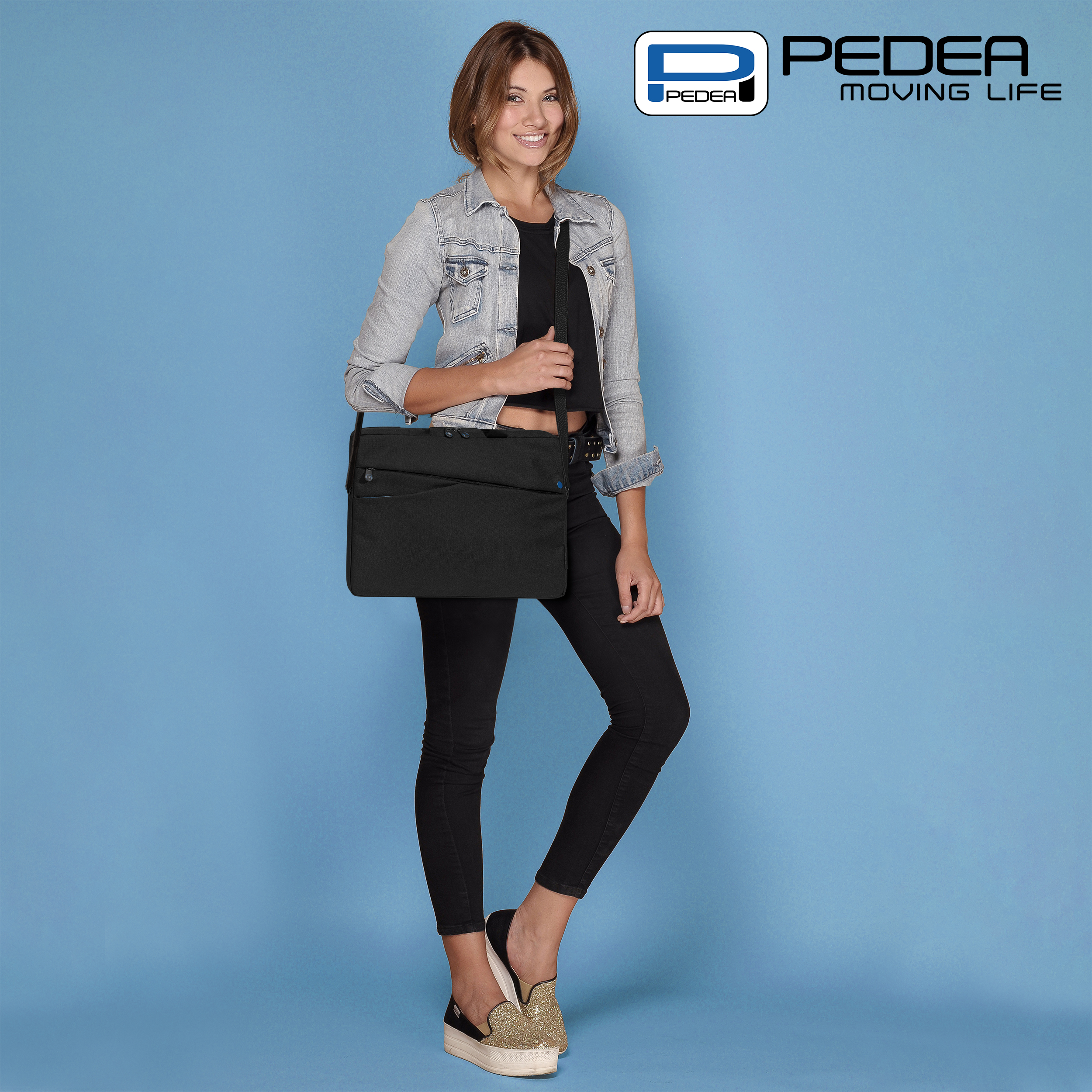 Frau in Jeansjacke hält schwarze Tasche, blauer Hintergrund.